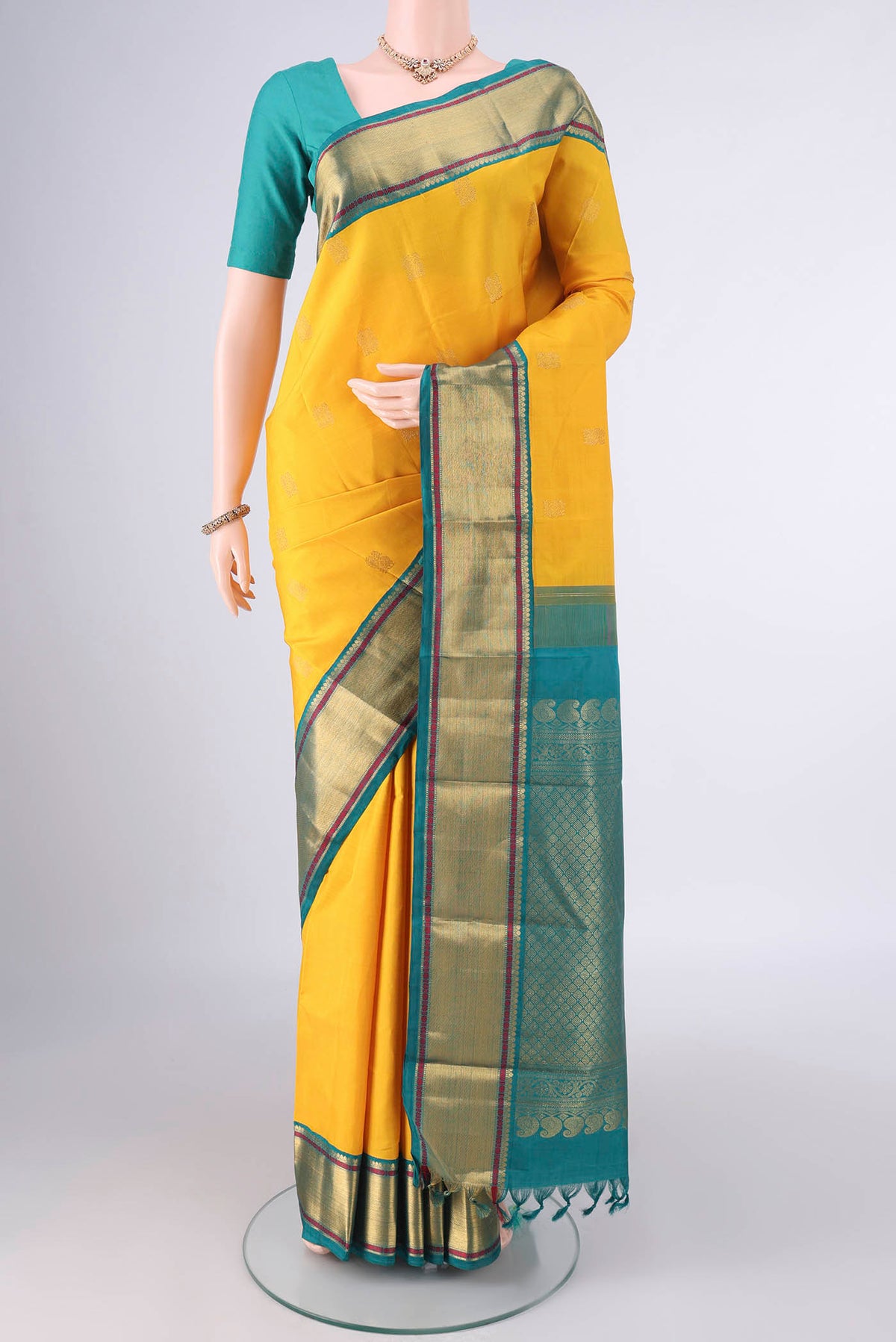 Pure Silk Yellow Kanchipuram Saree with Zari Butta on the body and Zari Border.  displayed on a mannequin