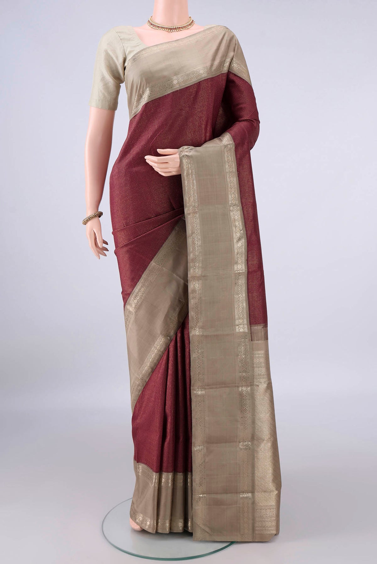 Pure Silk Maroon Kanchipuram Saree with Checked design on the body and Zari Border.  displayed on a mannequin