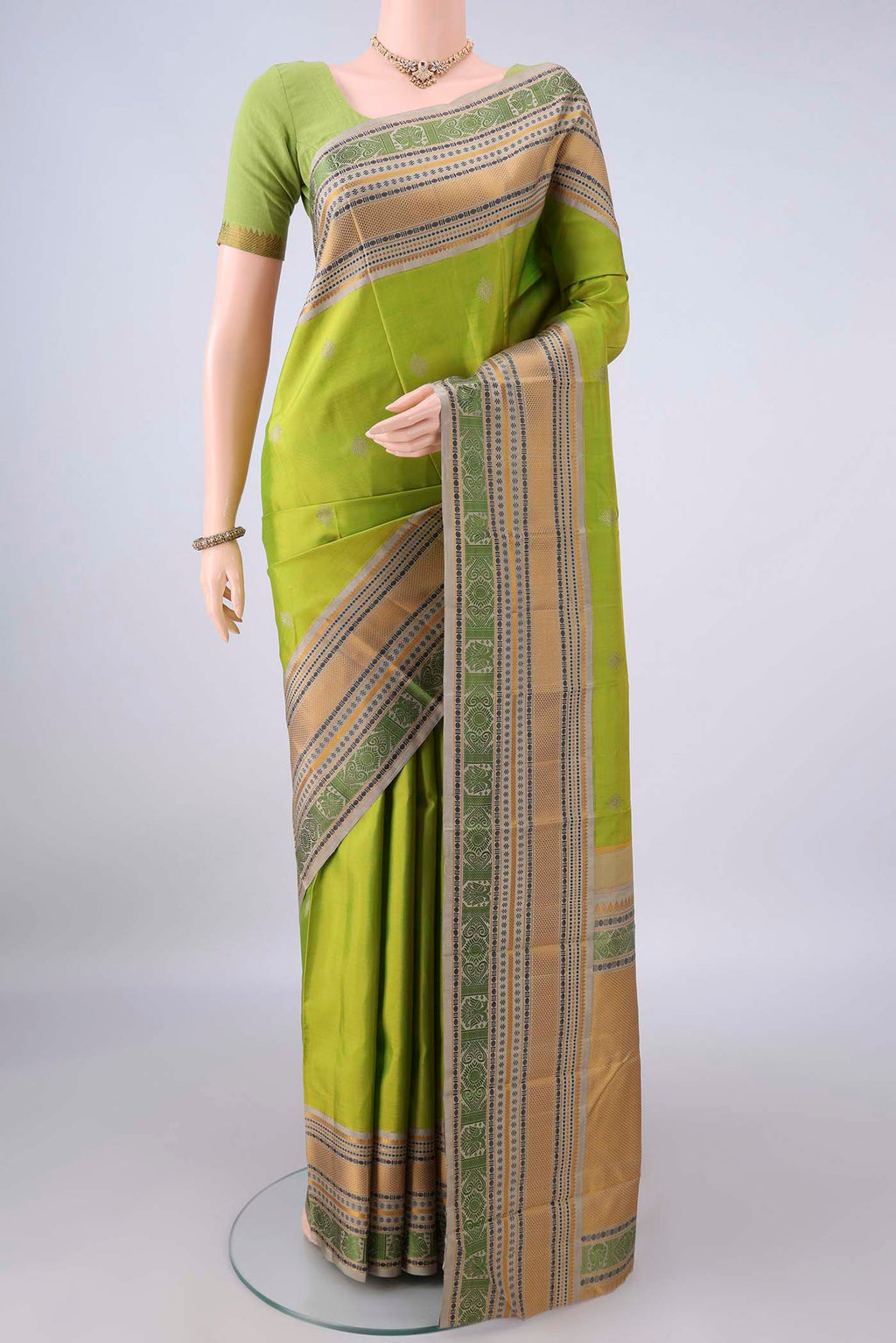 Pure Silk Light Green Kanjivaram Saree with Thread Butta on the body and Thread Border.  displayed on a mannequin