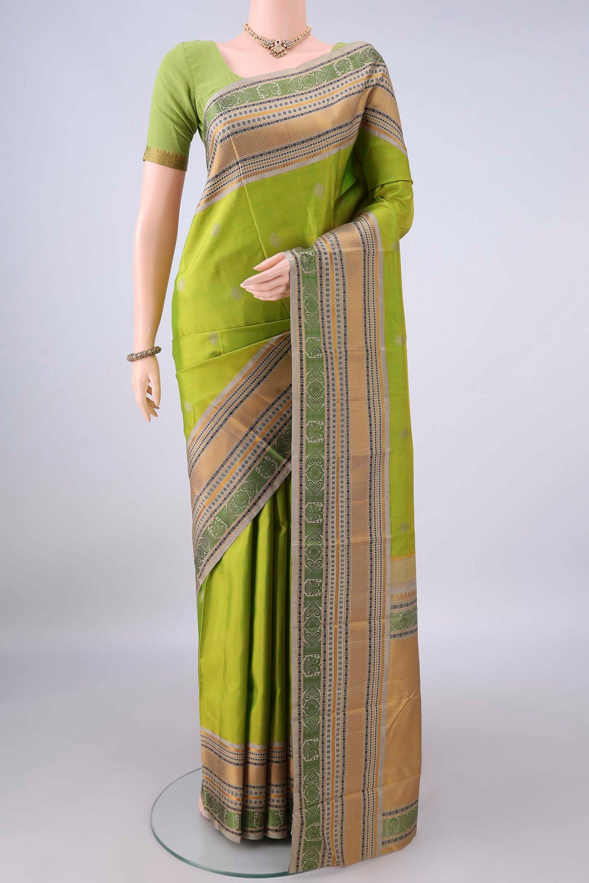 Pure Silk Light Green Kanjivaram Saree with Thread Butta on the body and Thread Border.  displayed on a mannequin