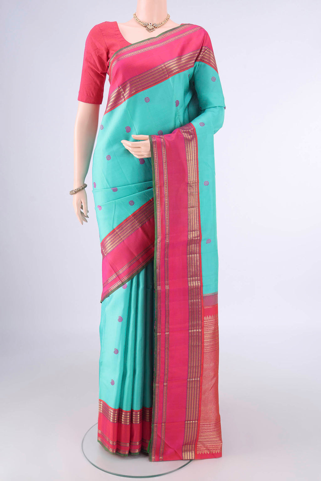 Pure Silk Pure Zari Turquoise Kanchipuram Saree with Thread Butta on the body and Zari Border.  displayed on a mannequin