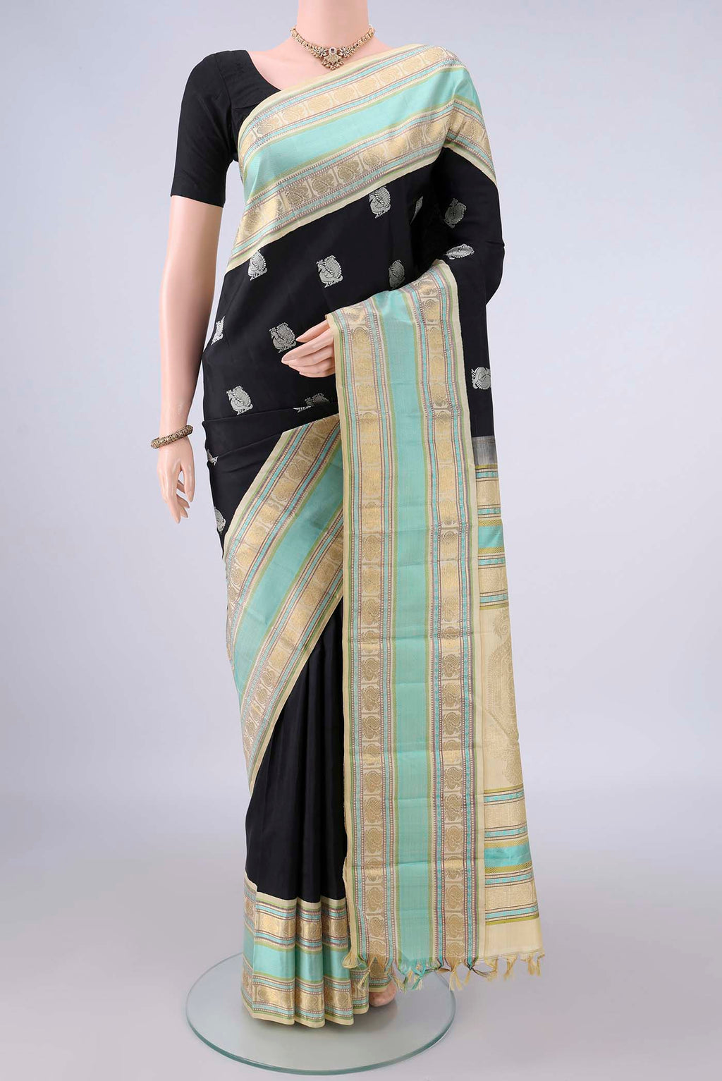 Pure Silk Black Kanchipuram Saree with Thread Butta on the body and Zari And Thread Border.  displayed on a mannequin