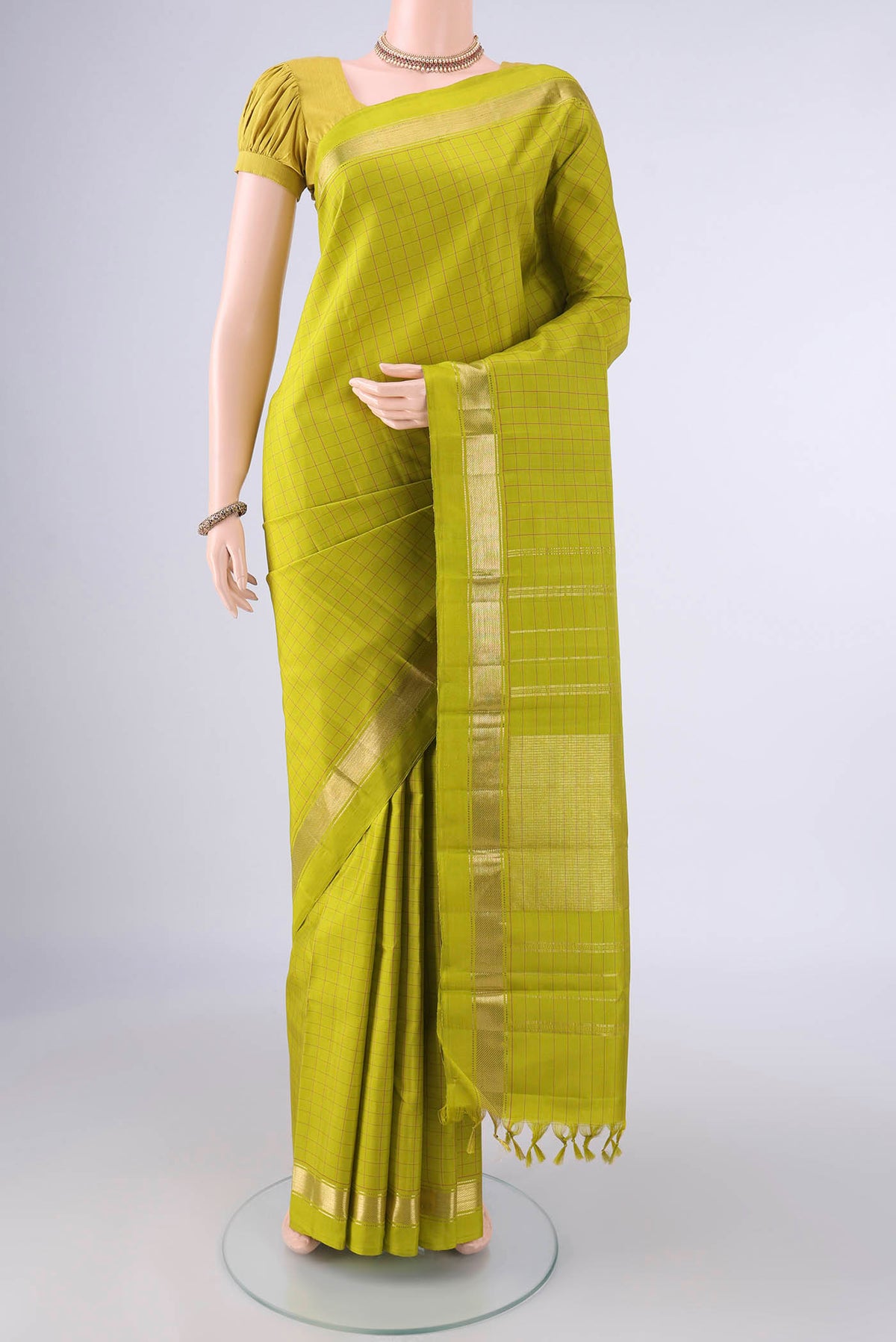 Pure Silk Green Kanjivaram Saree with Checked design on the body and Zari Border.  displayed on a mannequin