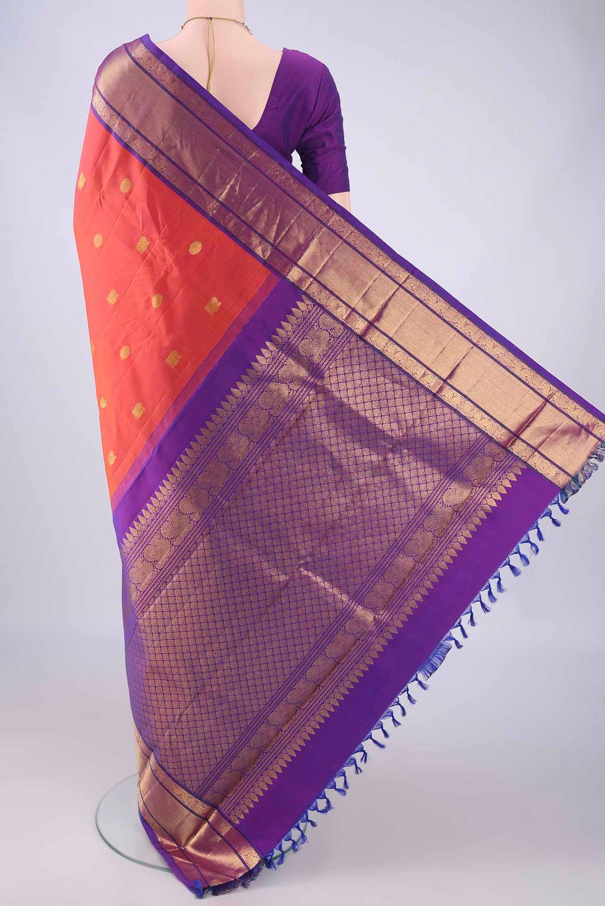 Flat view of Orange Kanchipuram Silk Saree with Zari Butta on the body and Zari Border. 