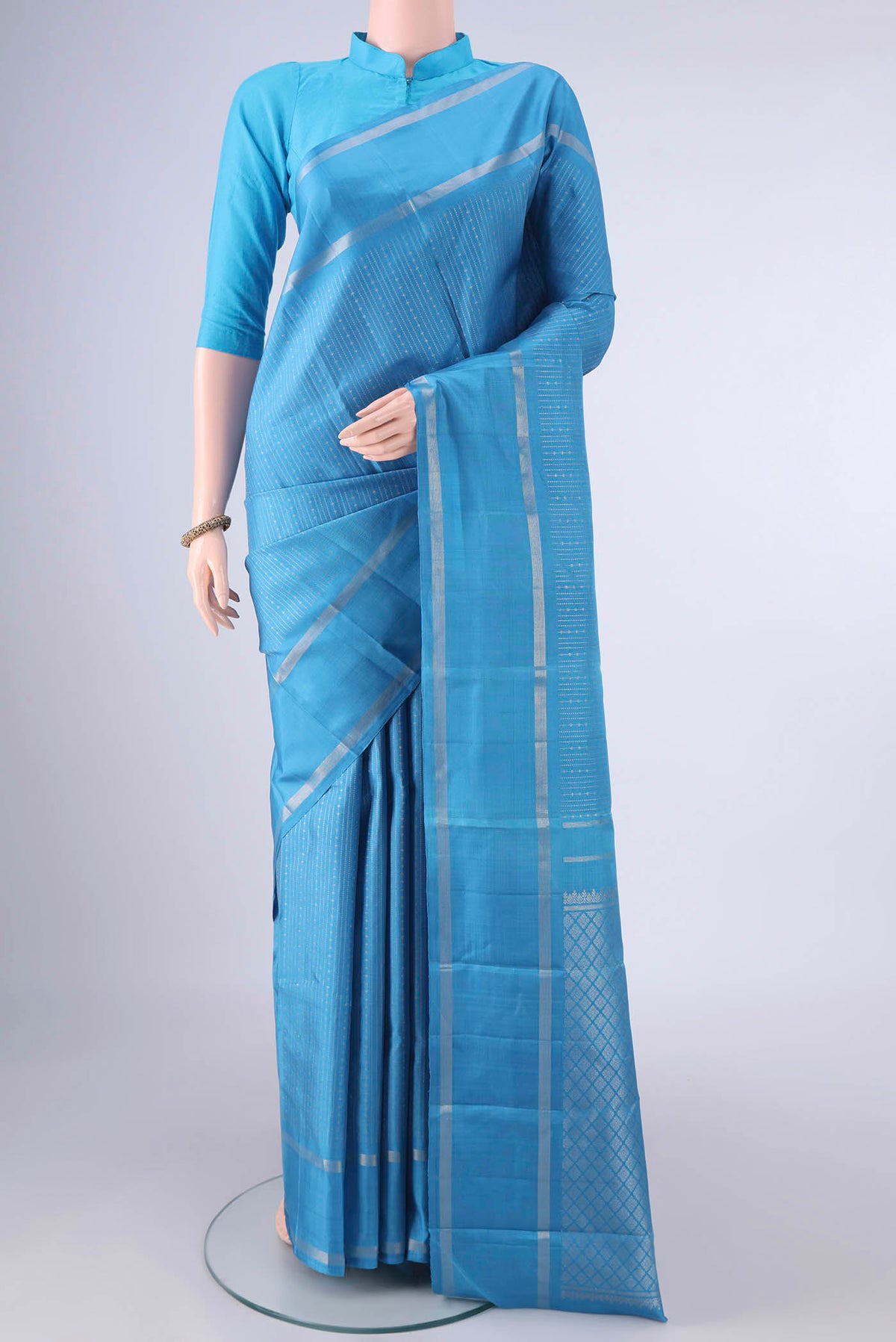 Pure Silk Blue Kanchipuram Saree with Stripes on the body and Zari Border.  displayed on a mannequin