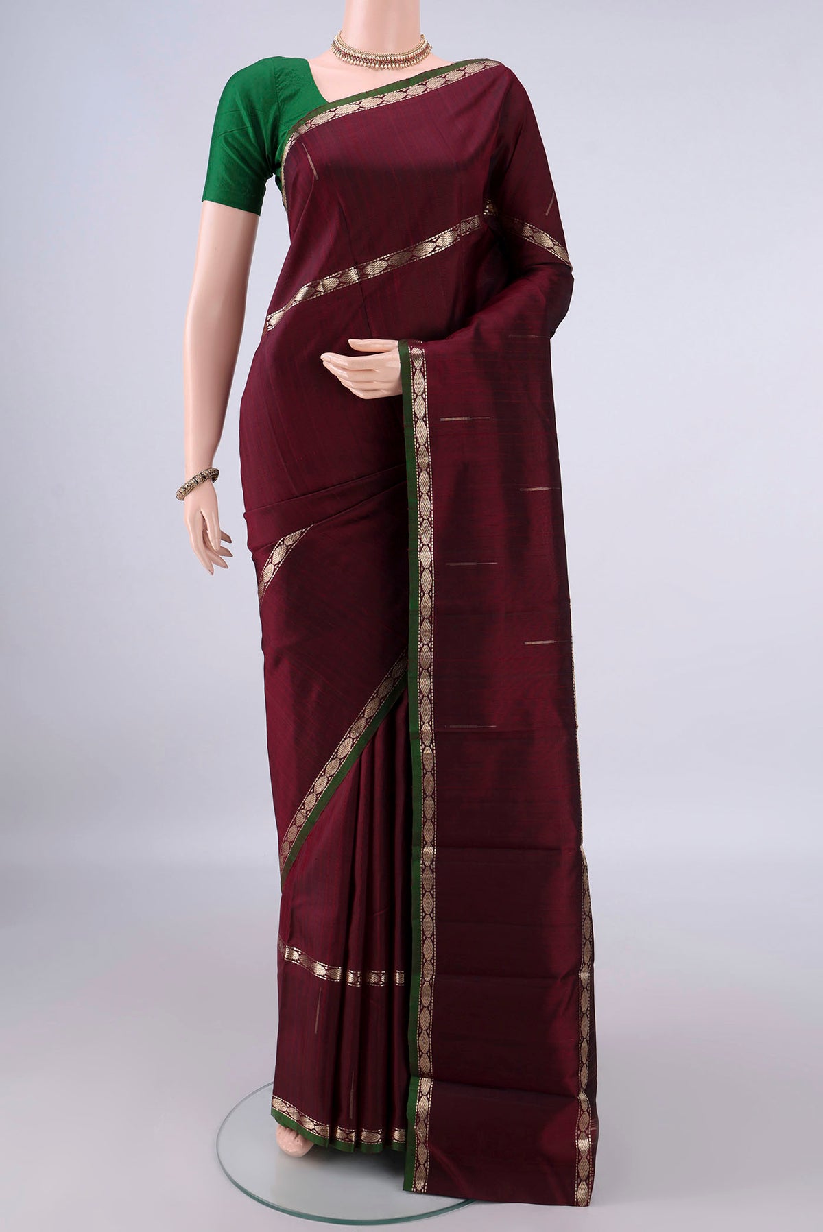 Pure Silk Maroon Kanchipuram Saree with Plain Body and Zari Border.  displayed on a mannequin