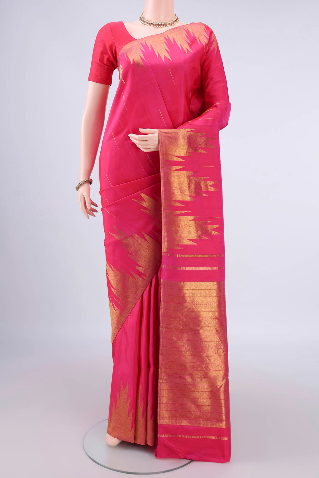 Pure Silk Rani Pink Kanjivaram Saree with Zari Butta on the body and Temple Border.  displayed on a mannequin