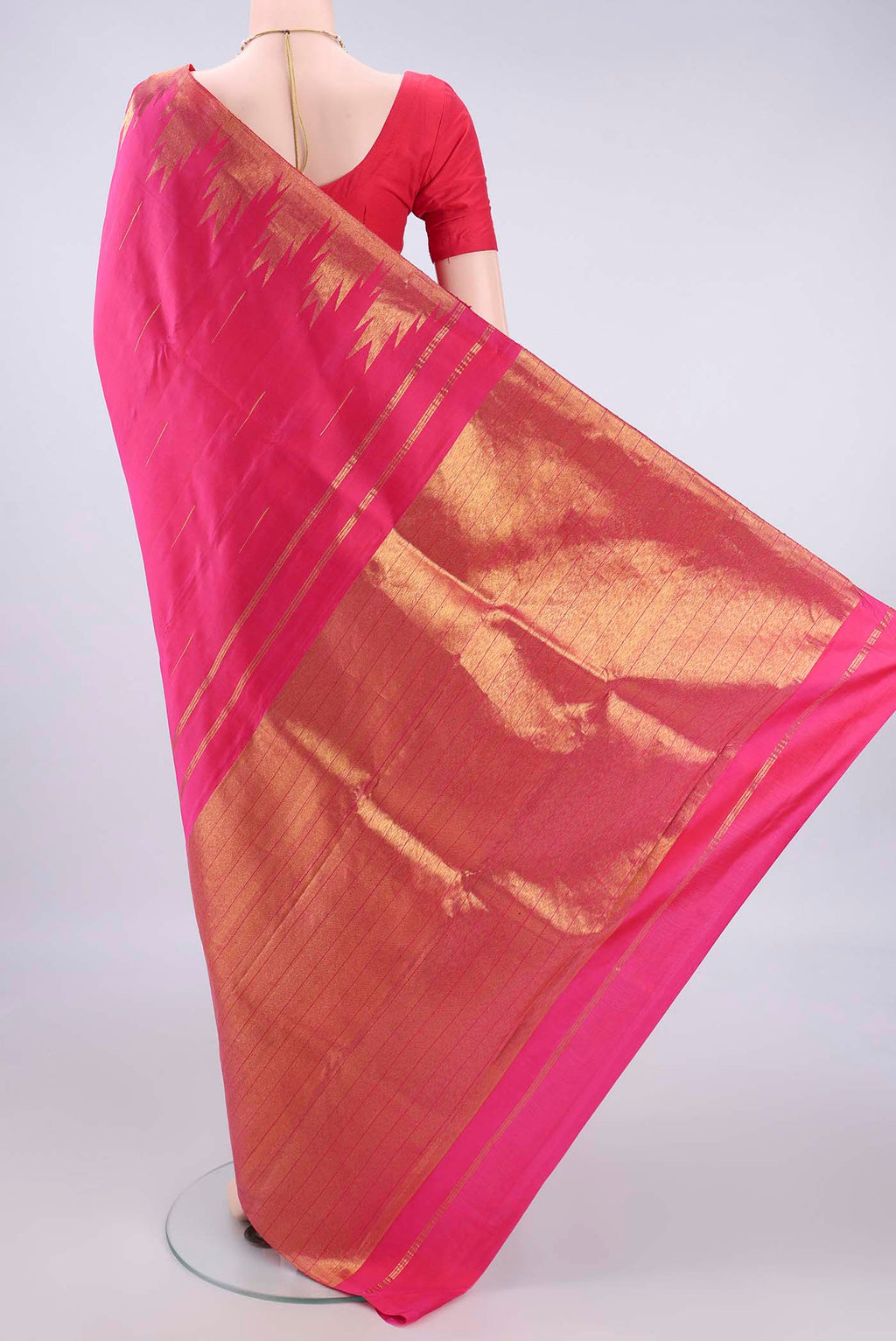 Flat view of Pure Silk Rani Pink Kanjivaram Saree with Zari Butta on the body and Temple Border. 