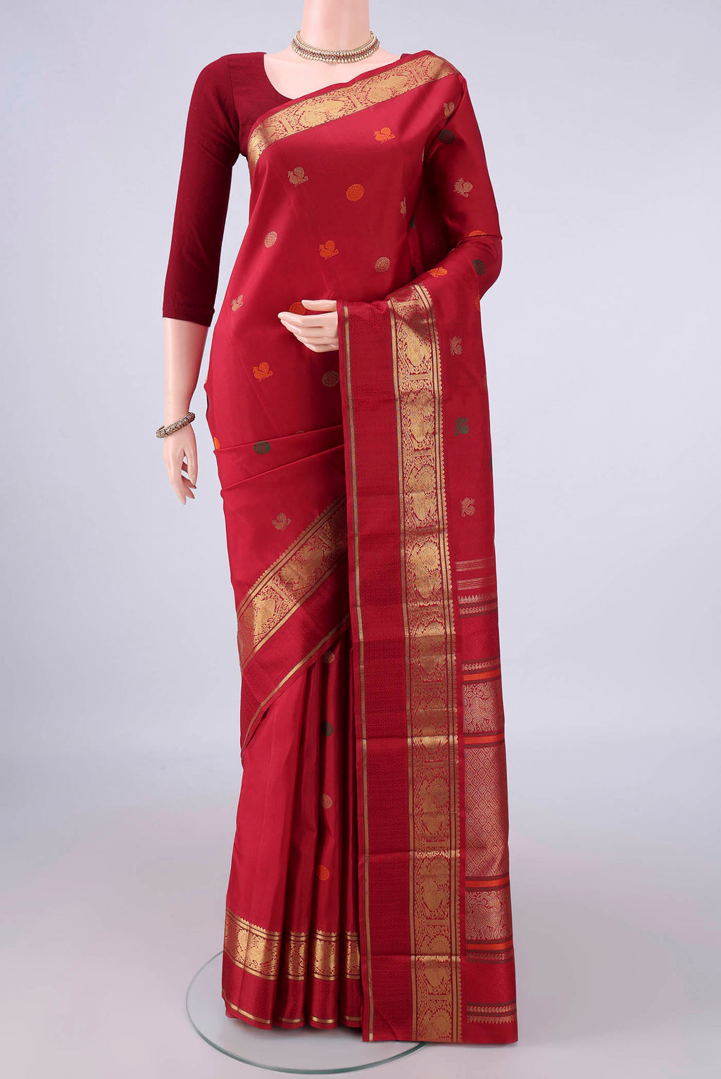 Pure Silk Pure Zari Maroon Kanjivaram Saree with Zari And Thread Butta on the body and Zari And Thread Border.  displayed on a mannequin