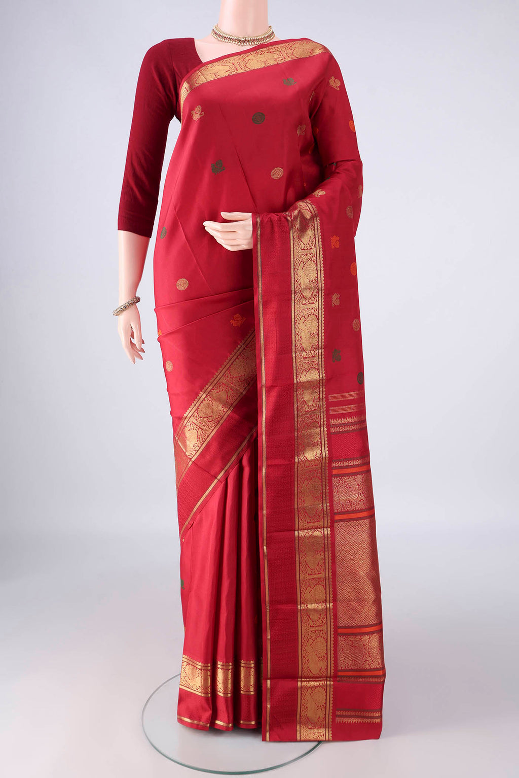 Pure Silk Pure Zari Red Kanjivaram Saree with Zari And Thread Butta on the body and Zari Border.  displayed on a mannequin