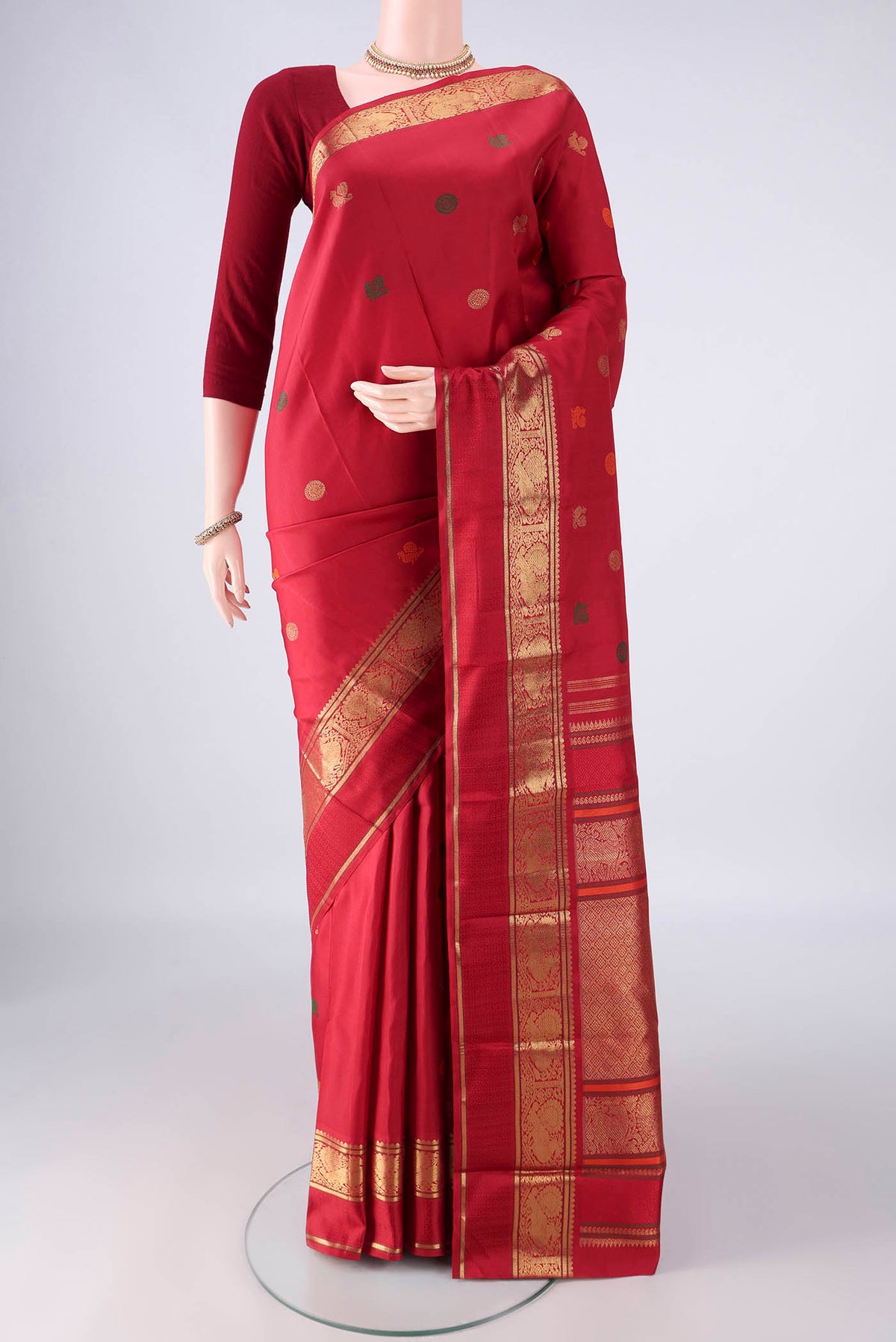 Pure Silk Pure Zari Red Kanjivaram Saree with Zari And Thread Butta on the body and Zari Border.  displayed on a mannequin