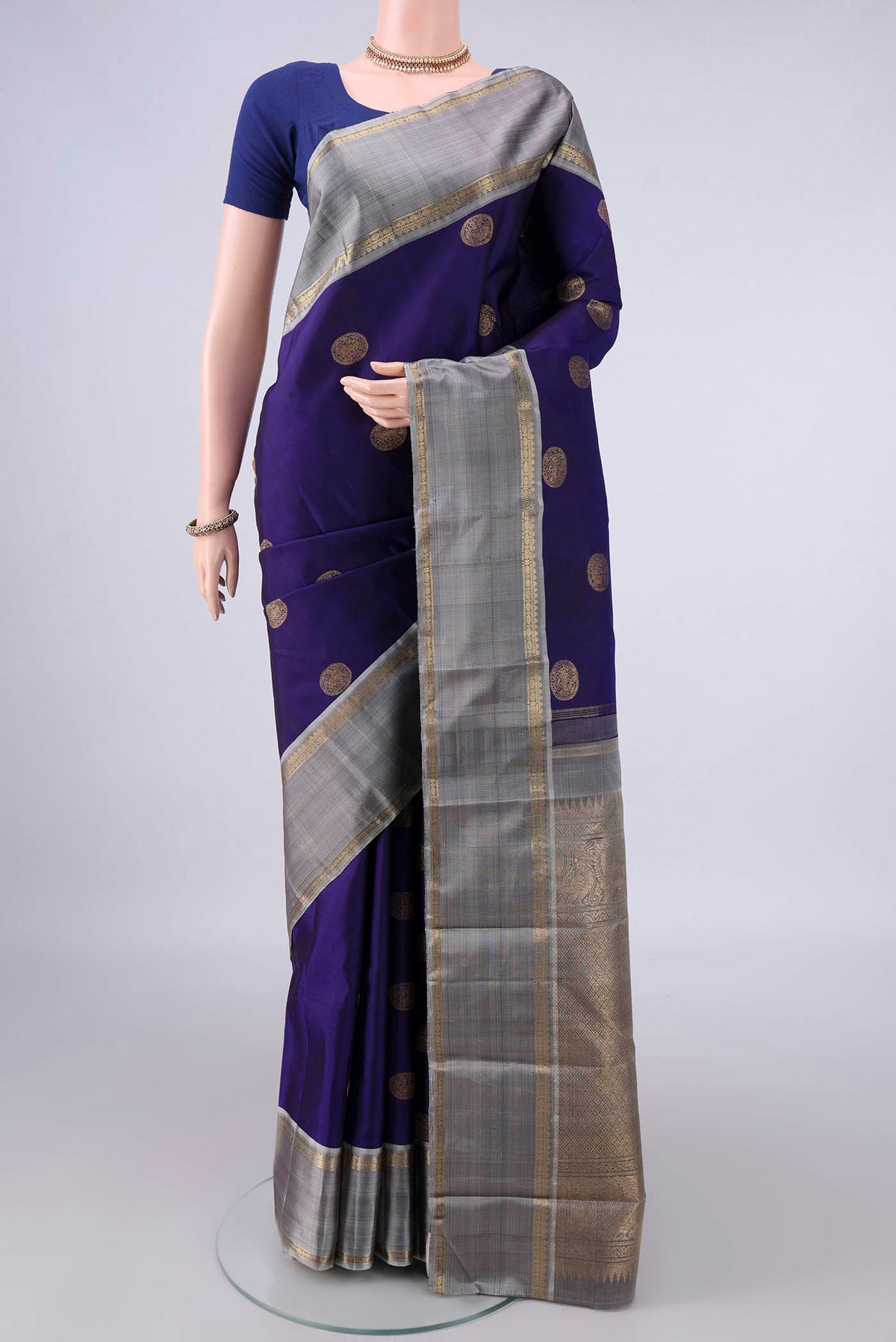 Pure Silk Navy Blue Kanchipuram Saree with Zari Butta on the body and Zari Border.  displayed on a mannequin