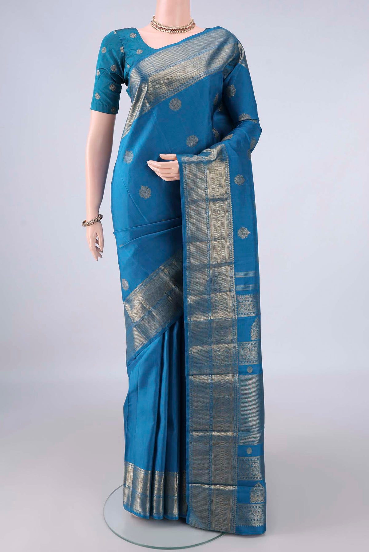 Pure Silk Pure Zari Blue Kanjivaram Saree with Zari Butta on the body and Zari Border.  displayed on a mannequin