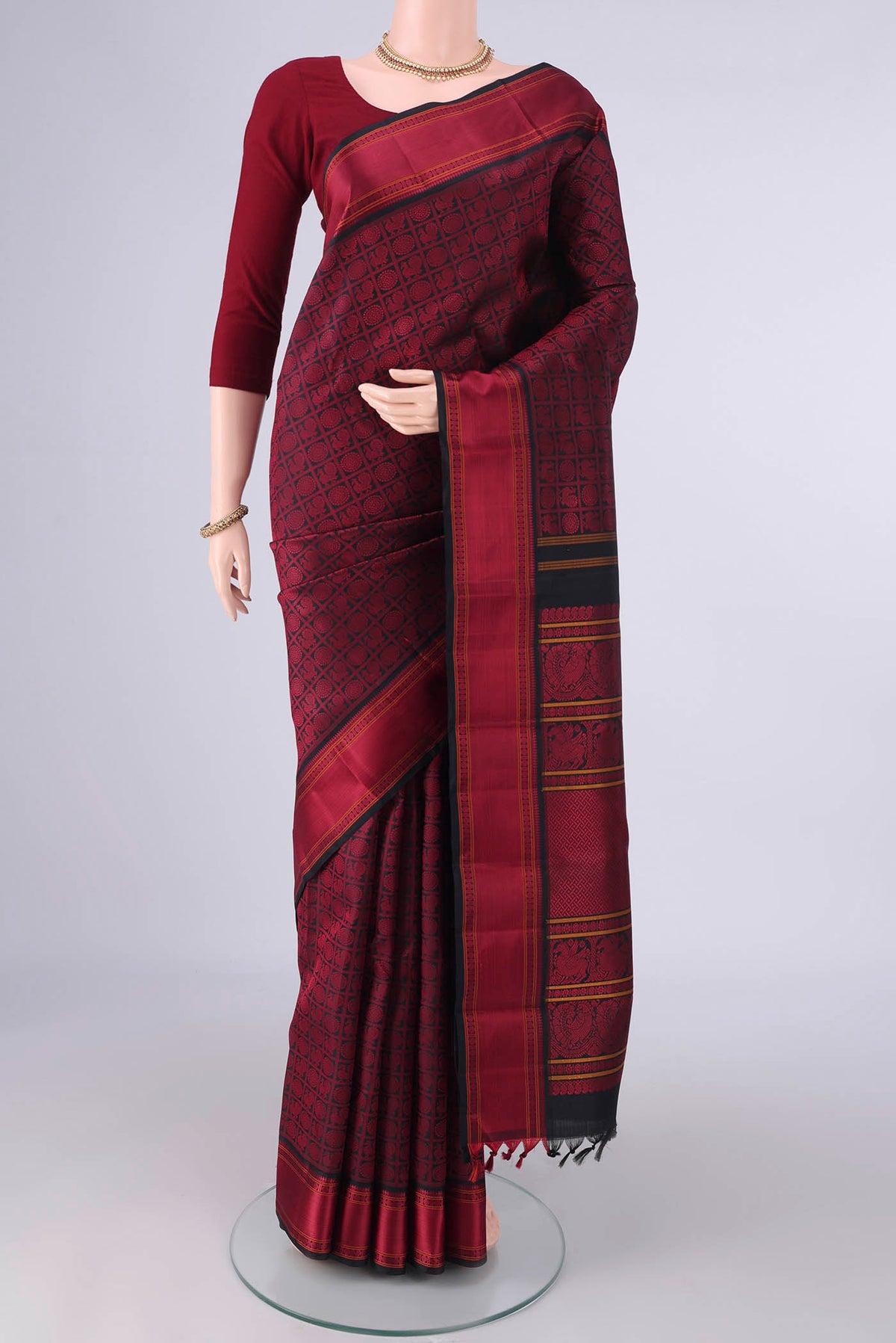 Pure Silk Black Kanjivaram Saree with Thread Brocade on the body and Thread Border.  displayed on a mannequin