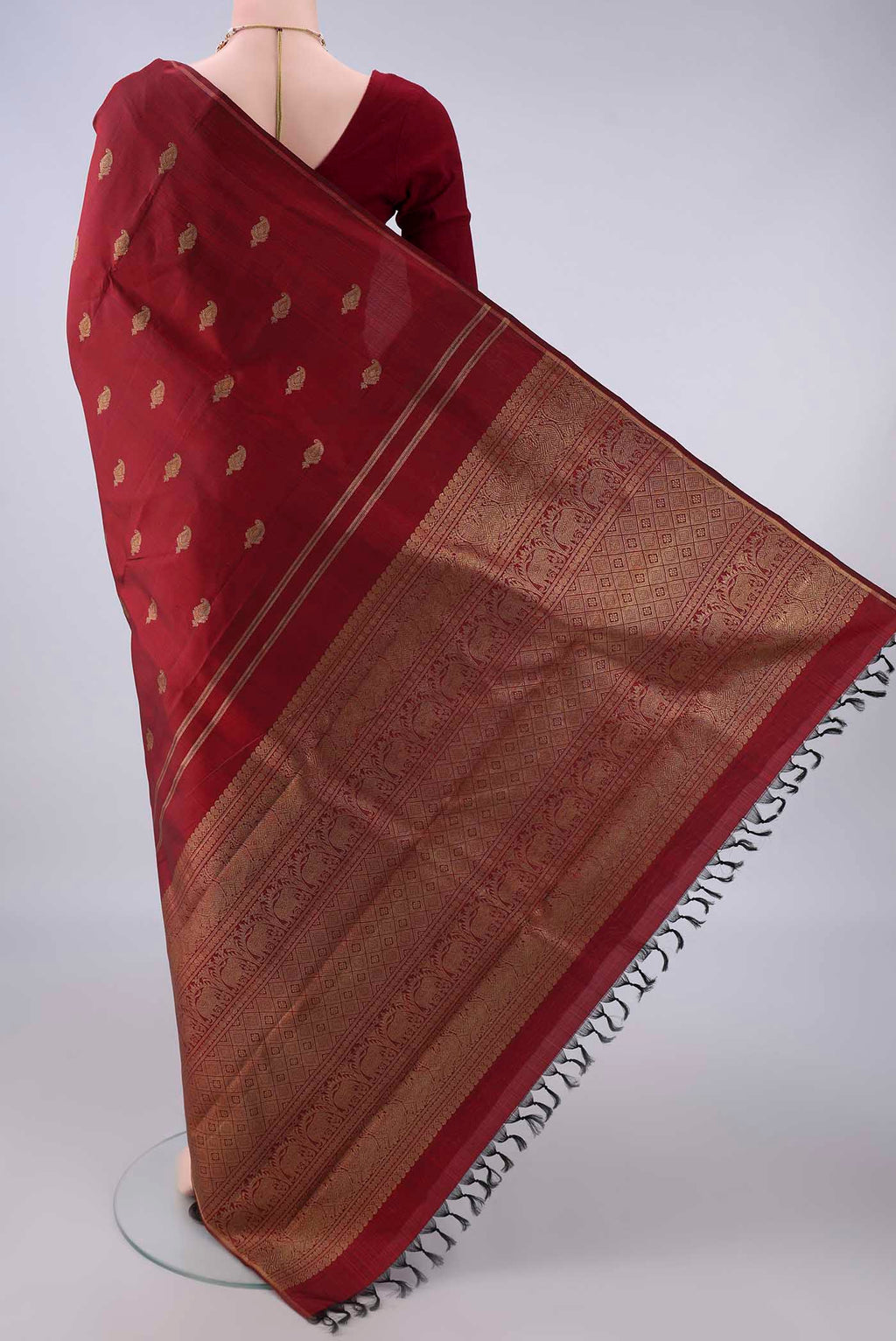 Flat view of Pure Silk Pure Zari Maroon Kanchipuram Saree with Zari Butta on the body and Thin Zari Line. 
