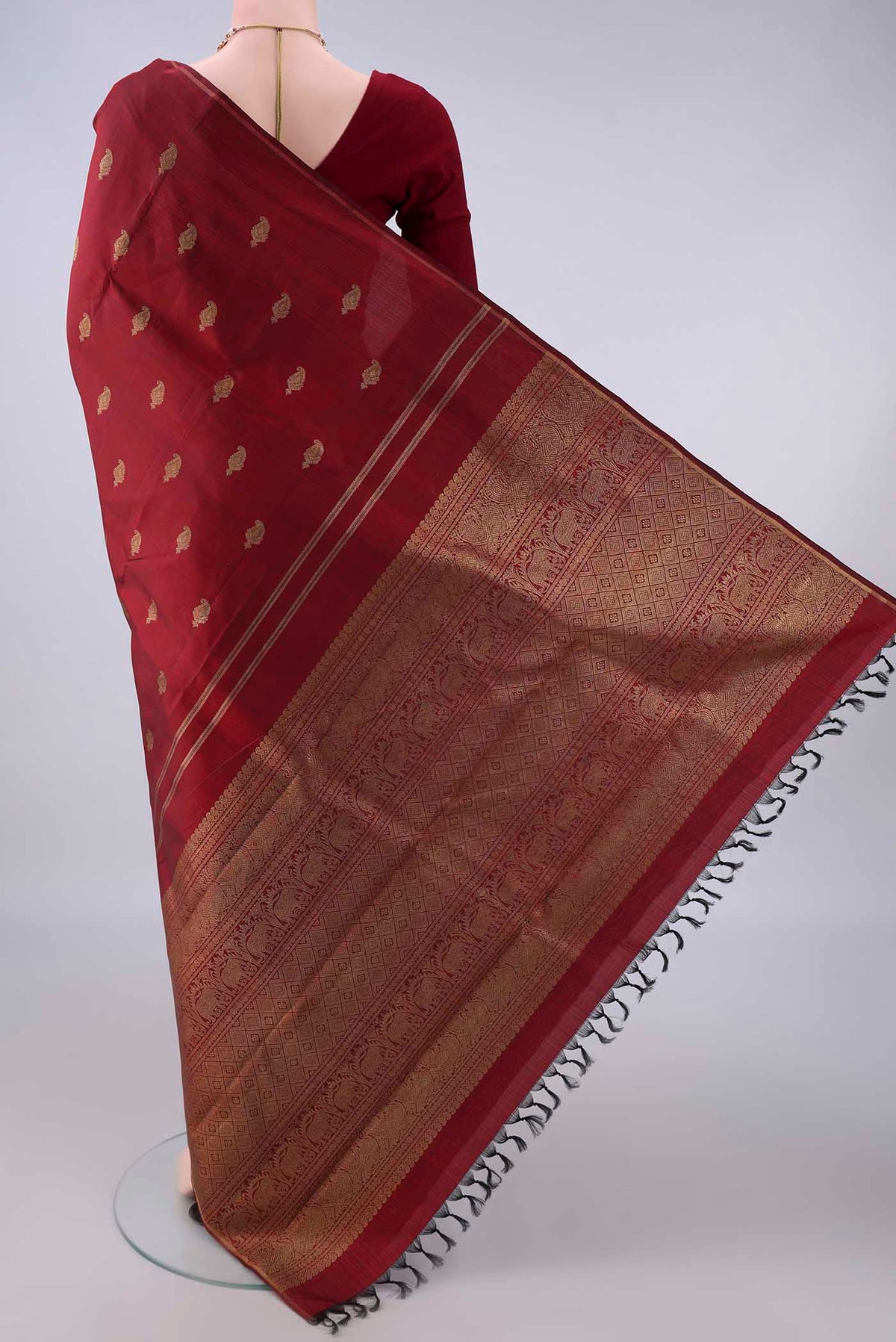 Flat view of Pure Silk Pure Zari Maroon Kanchipuram Saree with Zari Butta on the body and Thin Zari Line. 