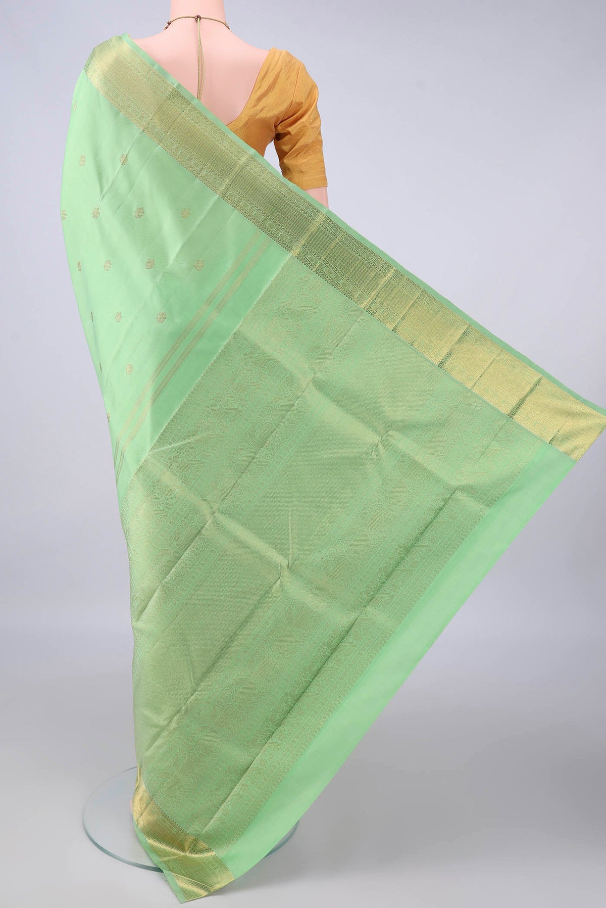 Flat view of Pure Silk Pure Zari Pista Green Kanjivaram Saree with Zari Butta on the body and Zari Border. 