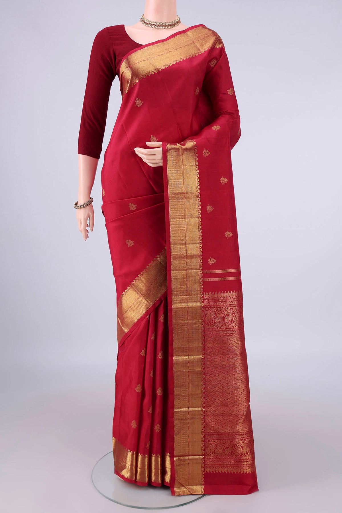 Pure Silk Pure Zari Maroon Kanjivaram Saree with Zari Butta on the body and Zari Border.  displayed on a mannequin
