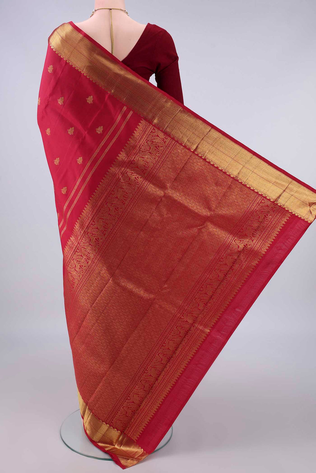 Flat view of Pure Silk Pure Zari Maroon Kanjivaram Saree with Zari Butta on the body and Zari Border. 