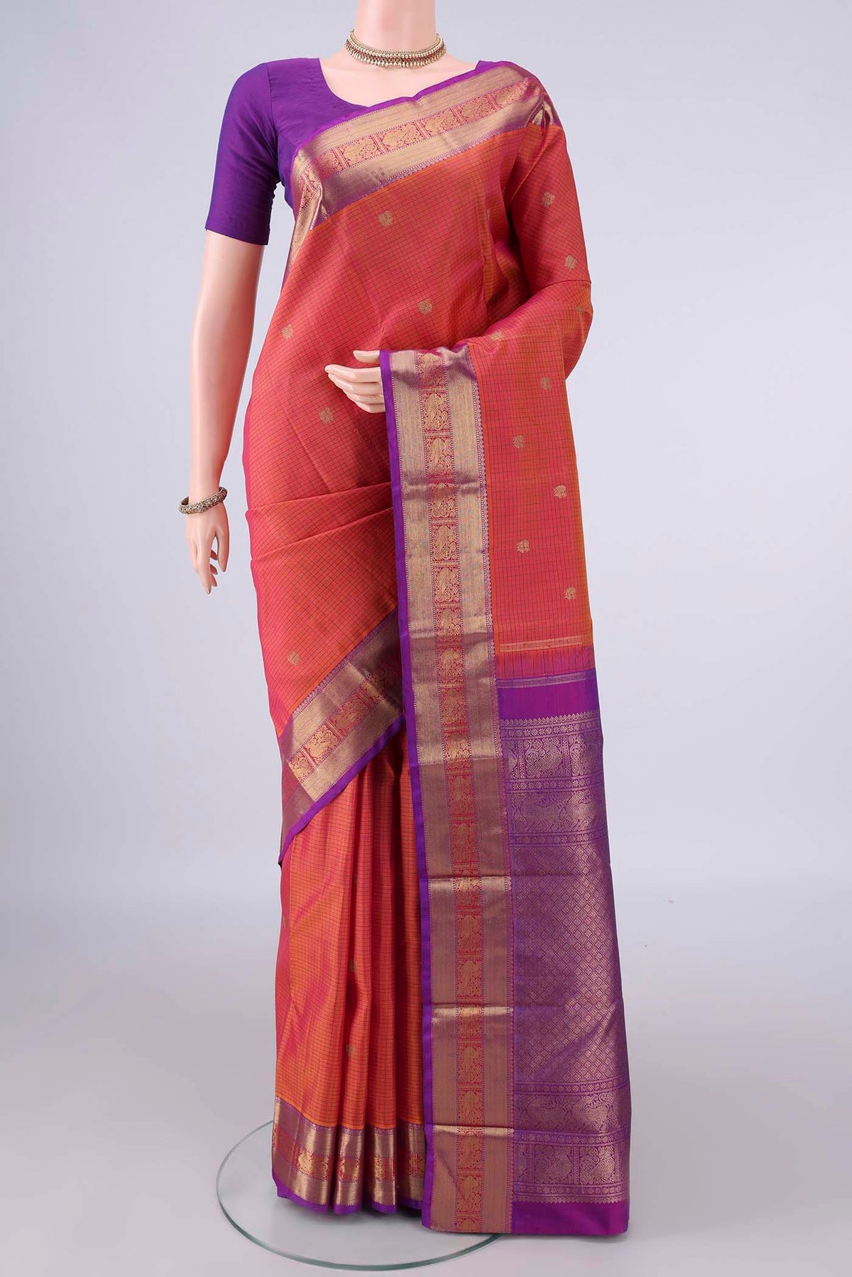 Pure Silk Brick Orange Kanjivaram Saree with Checked design on the body and Zari Border.  displayed on a mannequin