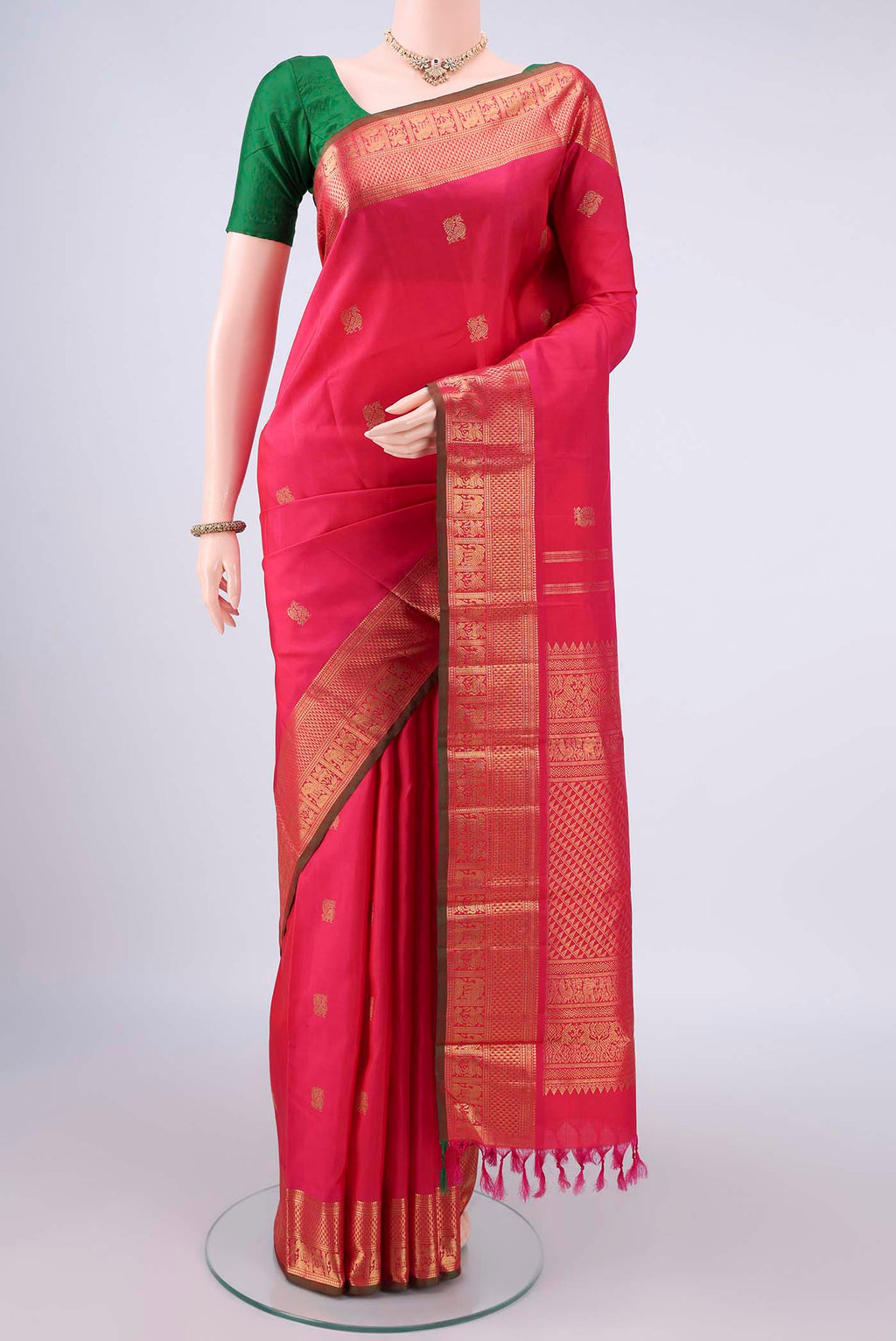 Pure Silk Pure Zari Coral Kanjivaram Saree with Zari Butta on the body and Zari Border.  displayed on a mannequin