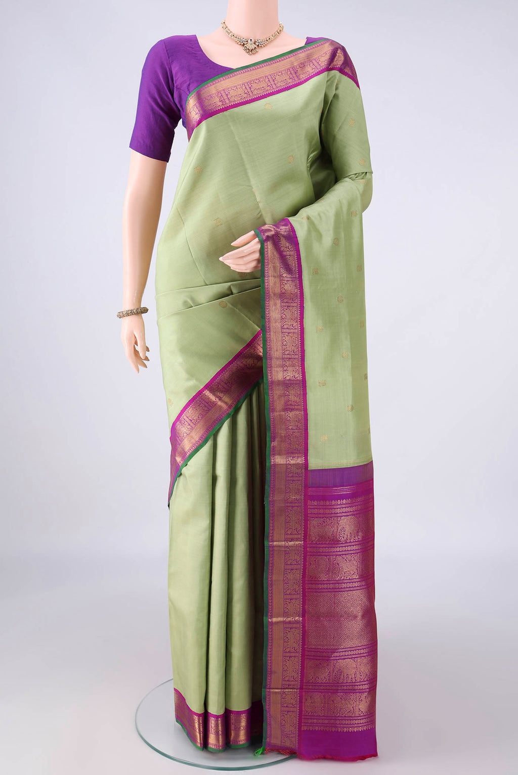 Pure Silk Pure Zari Pista Green Kanjivaram Saree with Zari Butta on the body and Zari Border.  displayed on a mannequin