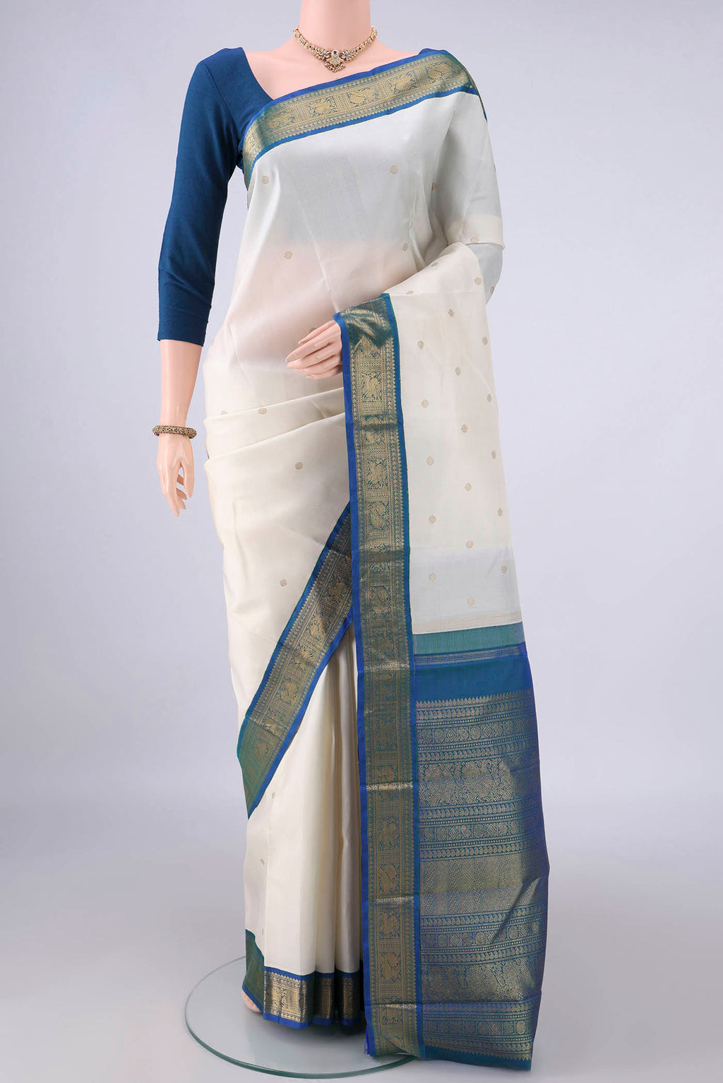 Pure Silk Off White Kanjivaram Saree with Zari Butta on the body and Zari Border.  displayed on a mannequin