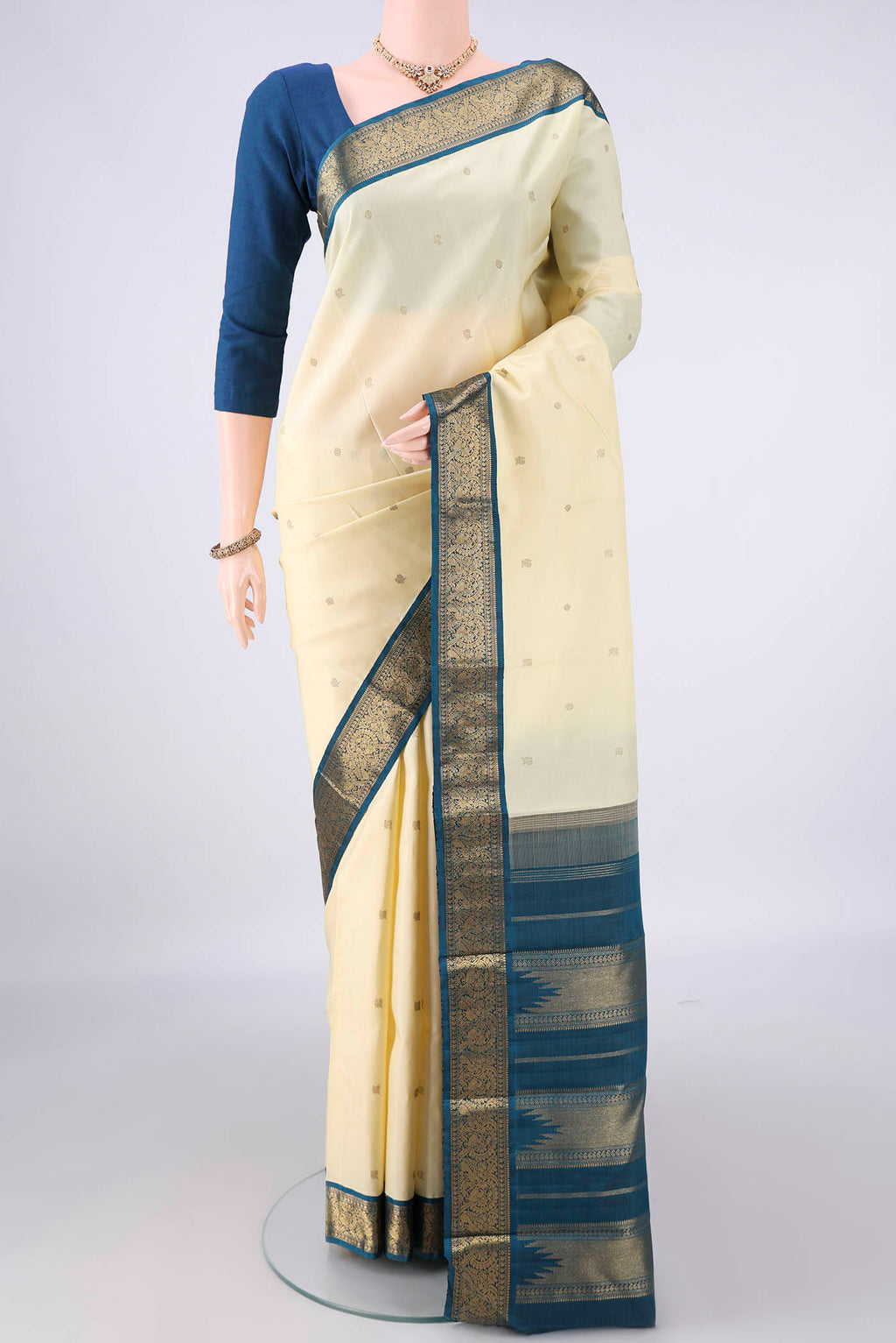 Pure Silk Pure Zari Cream Kanjivaram Saree with Zari Butta on the body and Zari Border.  displayed on a mannequin