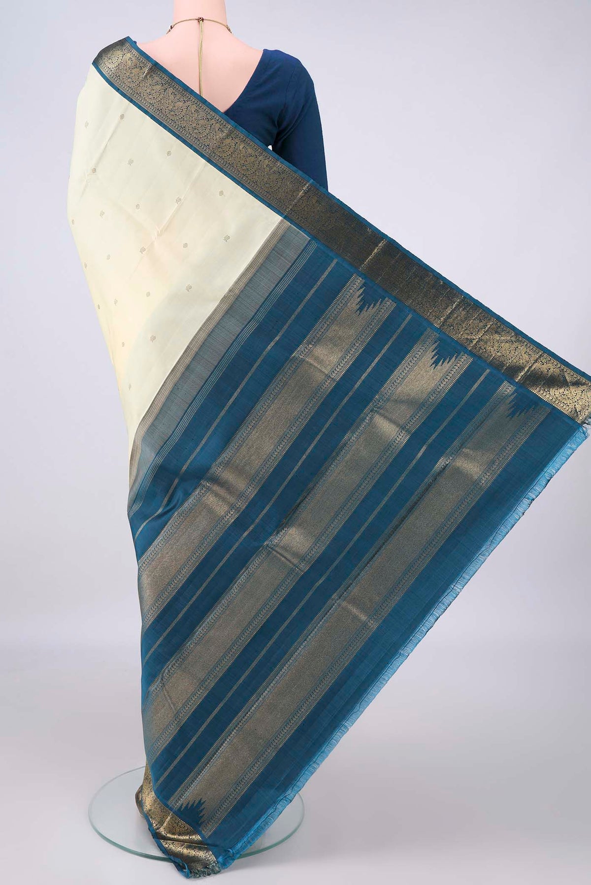 Flat view of Pure Silk Pure Zari Cream Kanjivaram Saree with Zari Butta on the body and Zari Border. 