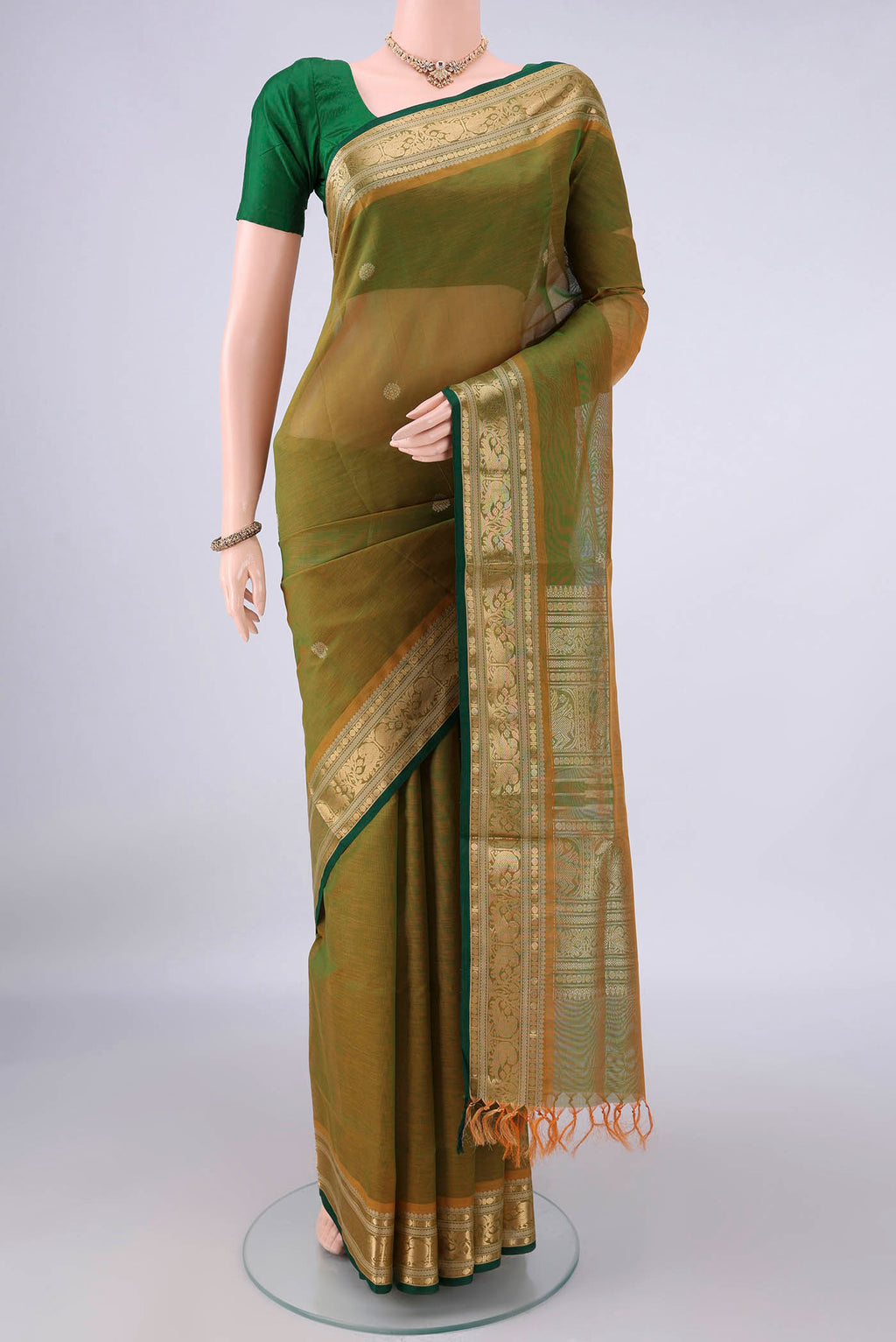 Mehandi Green Coimbatore Cotton Saree with Zari Butta on the body and Zari Border.  displayed on a mannequin