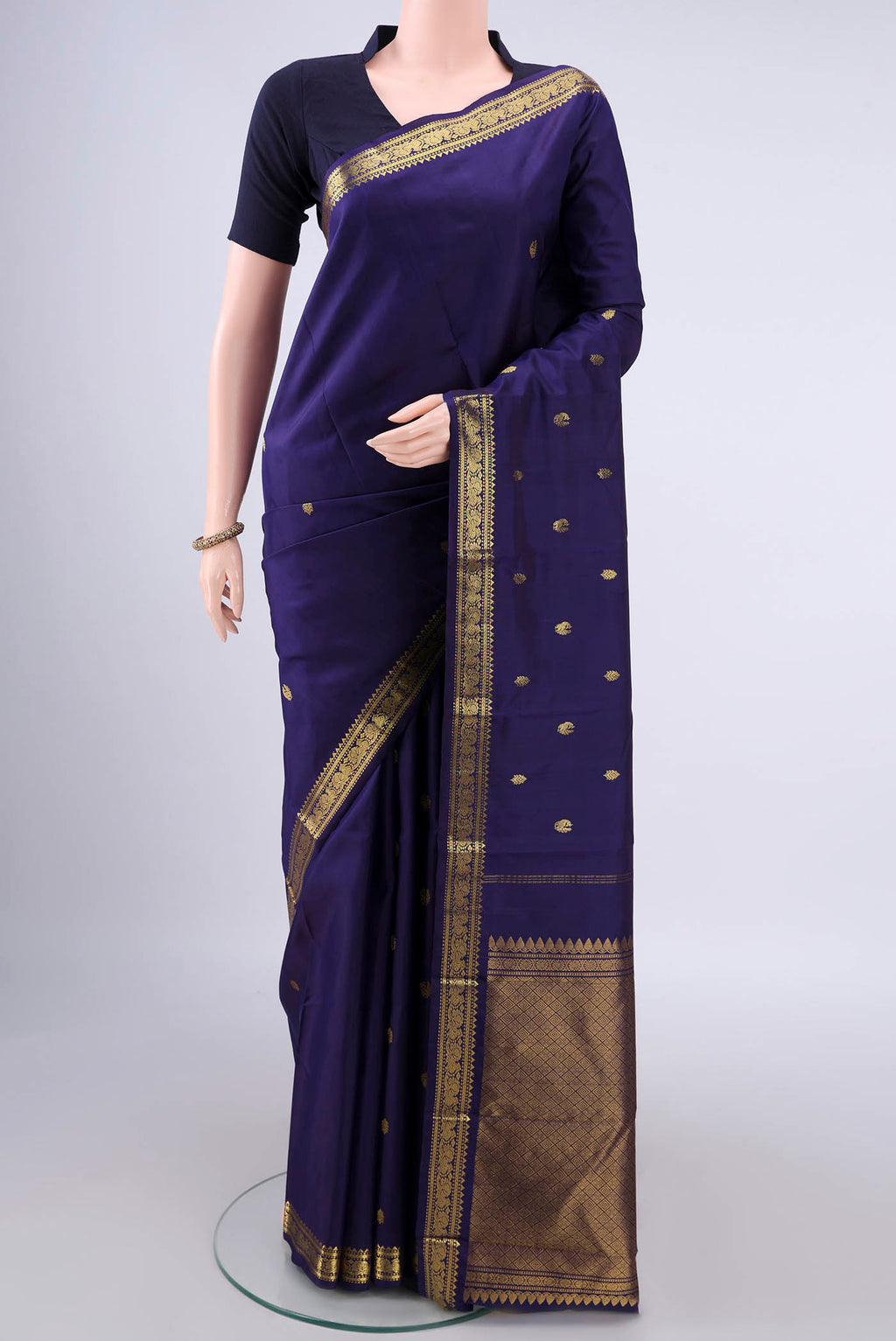 Pure Silk Navy Blue Kanchipuram Saree with Zari Butta on the body and Zari Border.  displayed on a mannequin