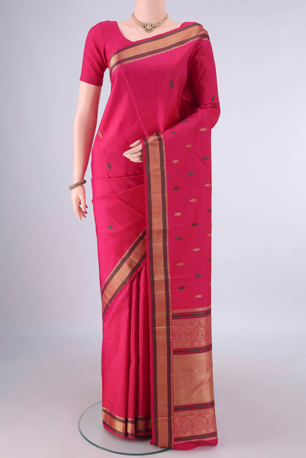 Pure Silk Rani Pink Kanjivaram Saree with Thread Butta on the body and Thread Border.  displayed on a mannequin