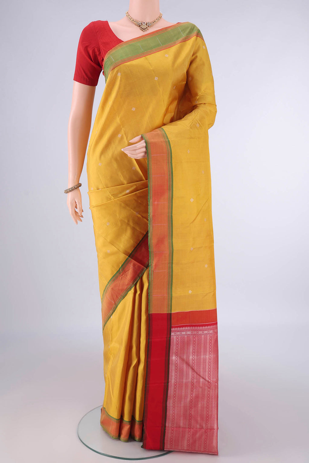 Pure Silk Mustard Kanchipuram Saree with Thread Butta on the body and Plain Border.  displayed on a mannequin