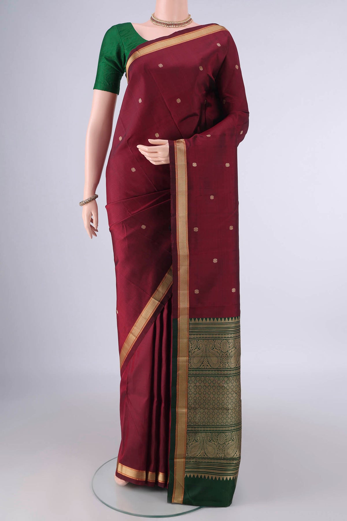 Pure Silk Maroon Kanjivaram Saree with Thread Butta on the body and Thread Border.  displayed on a mannequin