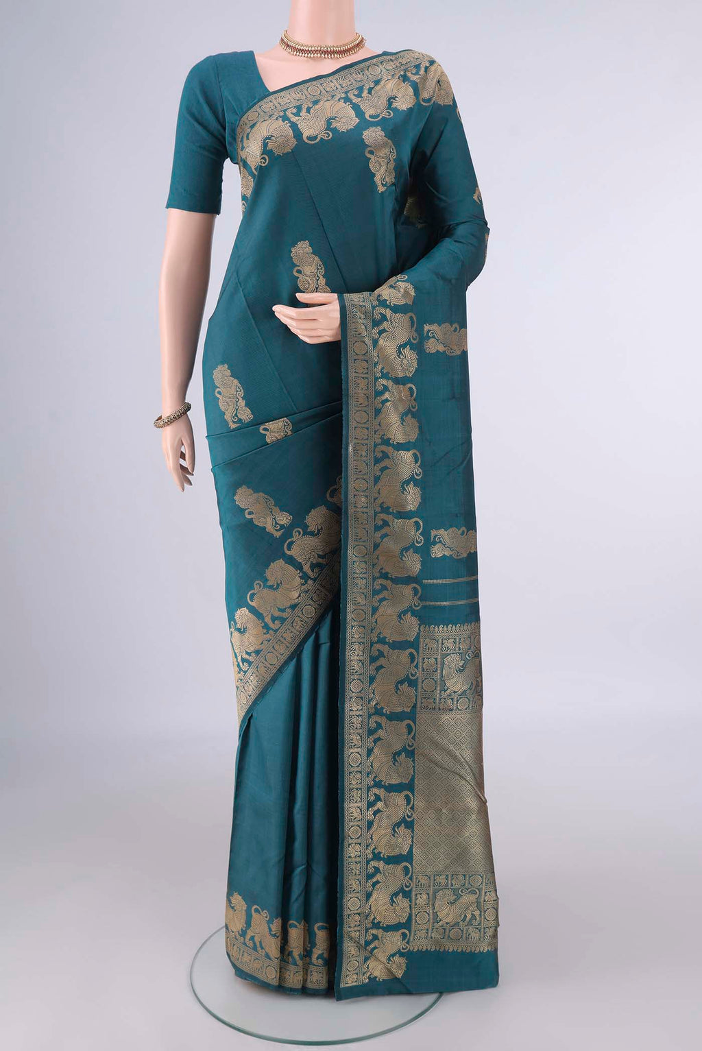 Pure Silk Teal Kanjivaram Saree with Thread Butta on the body and Thread Border.  displayed on a mannequin
