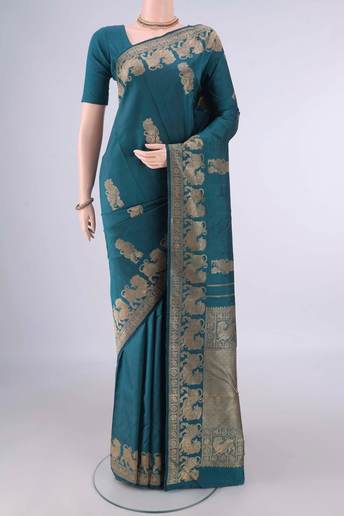 Pure Silk Teal Kanjivaram Saree with Thread Butta on the body and Thread Border.  displayed on a mannequin