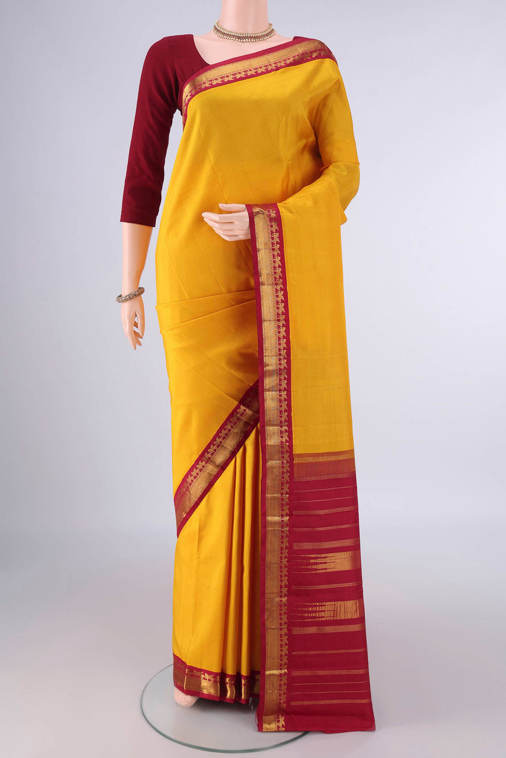 Pure Silk Yellow Kanjivaram Saree with Plain Body and Zari Border.  displayed on a mannequin
