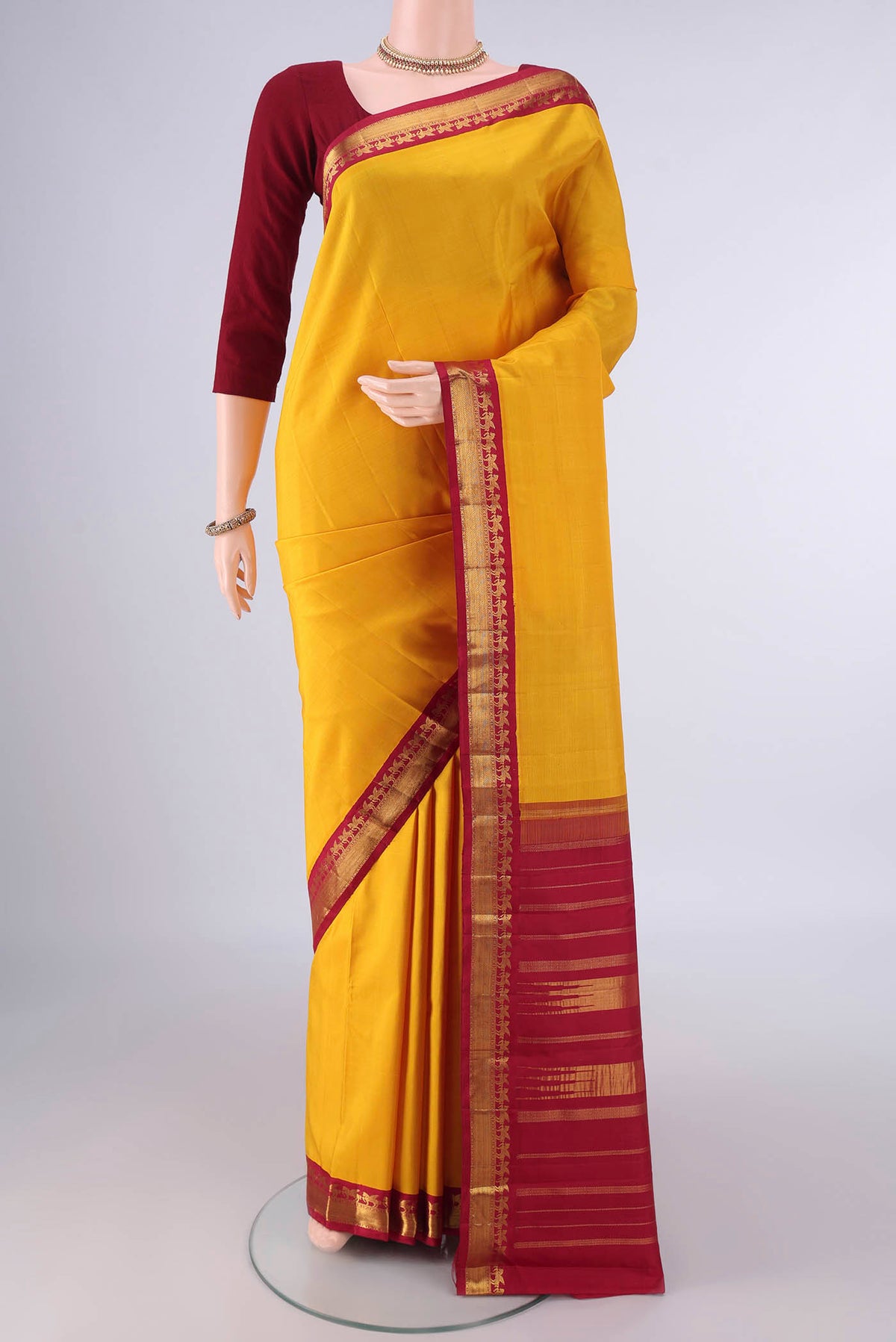 Pure Silk Yellow Kanjivaram Saree with Plain Body and Zari Border.  displayed on a mannequin