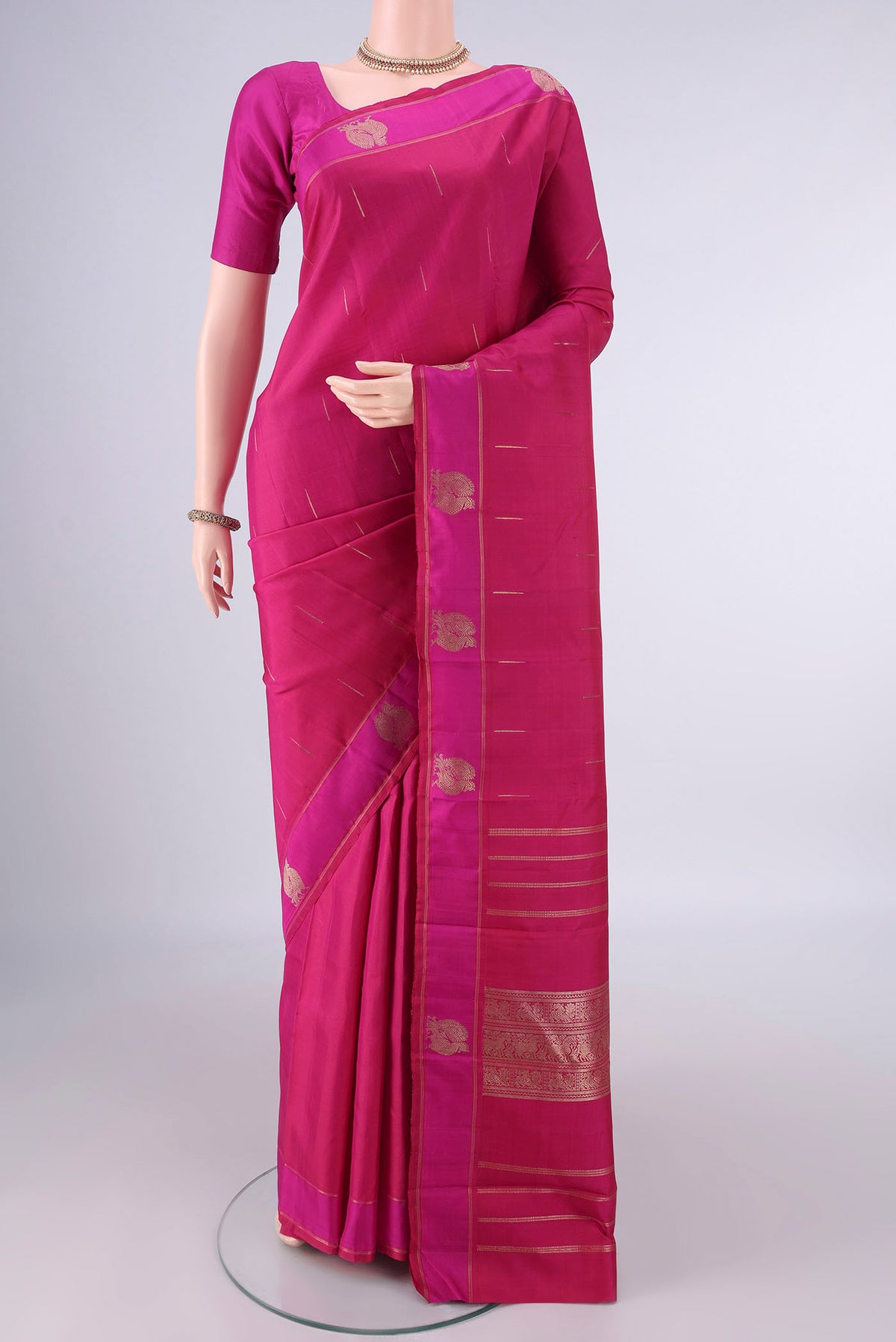 Pure Silk Pure Zari Rani Pink Kanchipuram Saree with Zari Butta on the body and Zari Border.  displayed on a mannequin