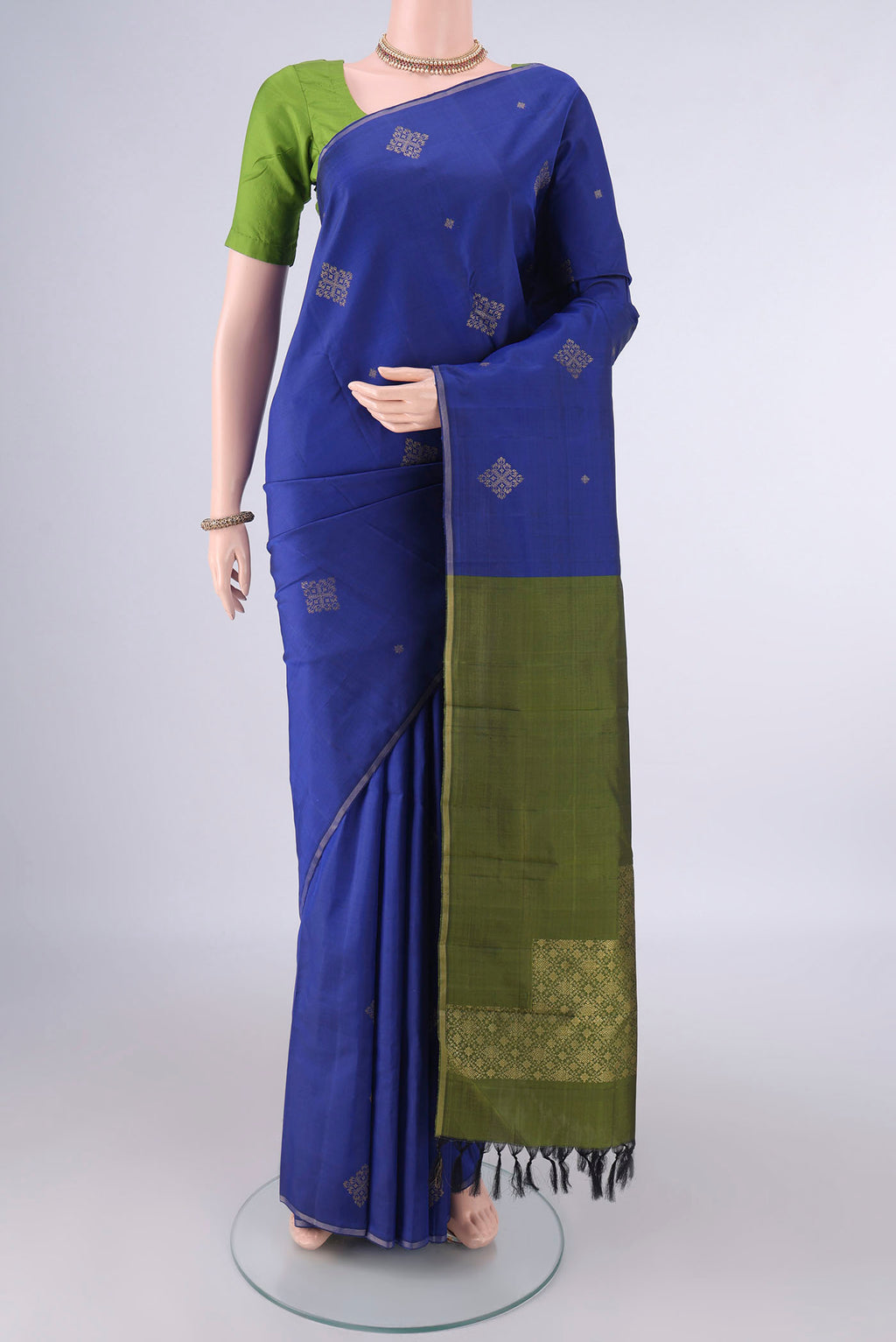 Pure Silk Blue Kanchipuram Saree with Zari Butta on the body and Thin Zari Line.  displayed on a mannequin