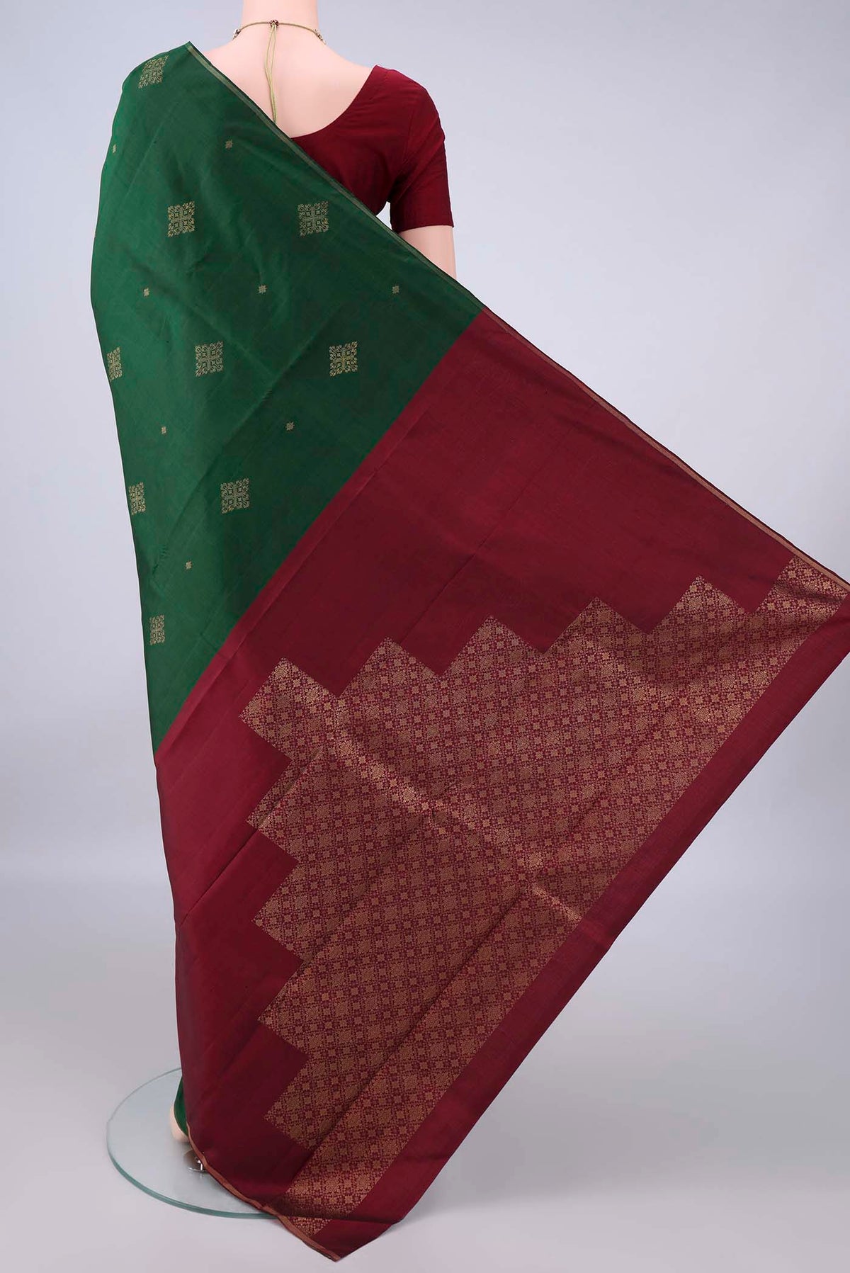 Flat view of Pure Silk Bottle Green Kanchipuram Saree with Zari Butta on the body and Thin Zari Line. 