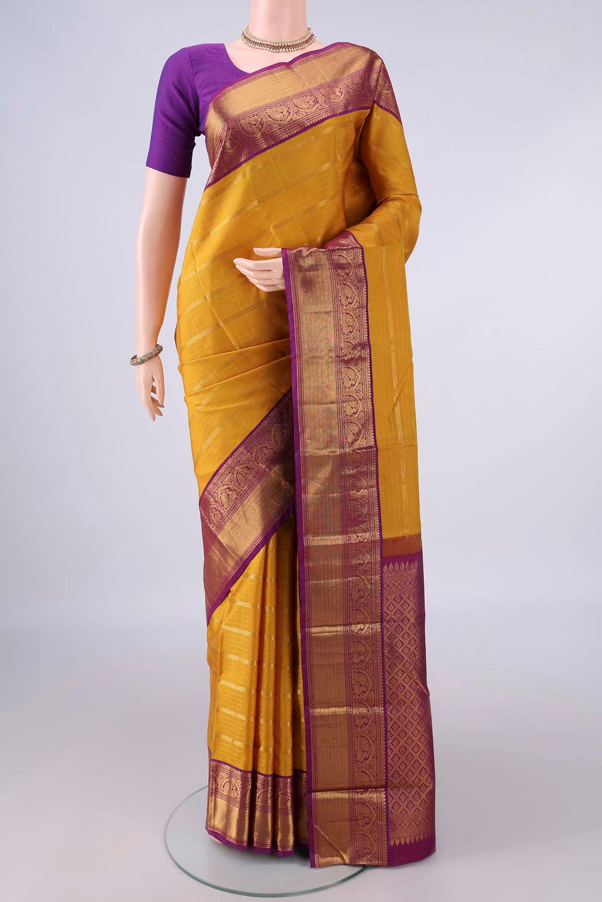 Pure Silk Mustard Kanjivaram Saree with Stripes on the body and Zari Border.  displayed on a mannequin