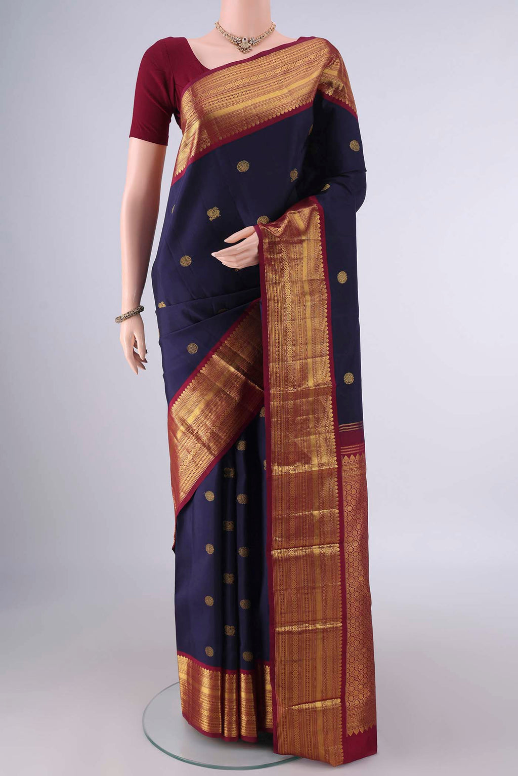Pure Silk Navy Blue Kanjivaram Saree with Zari Butta on the body and Zari Border.  displayed on a mannequin