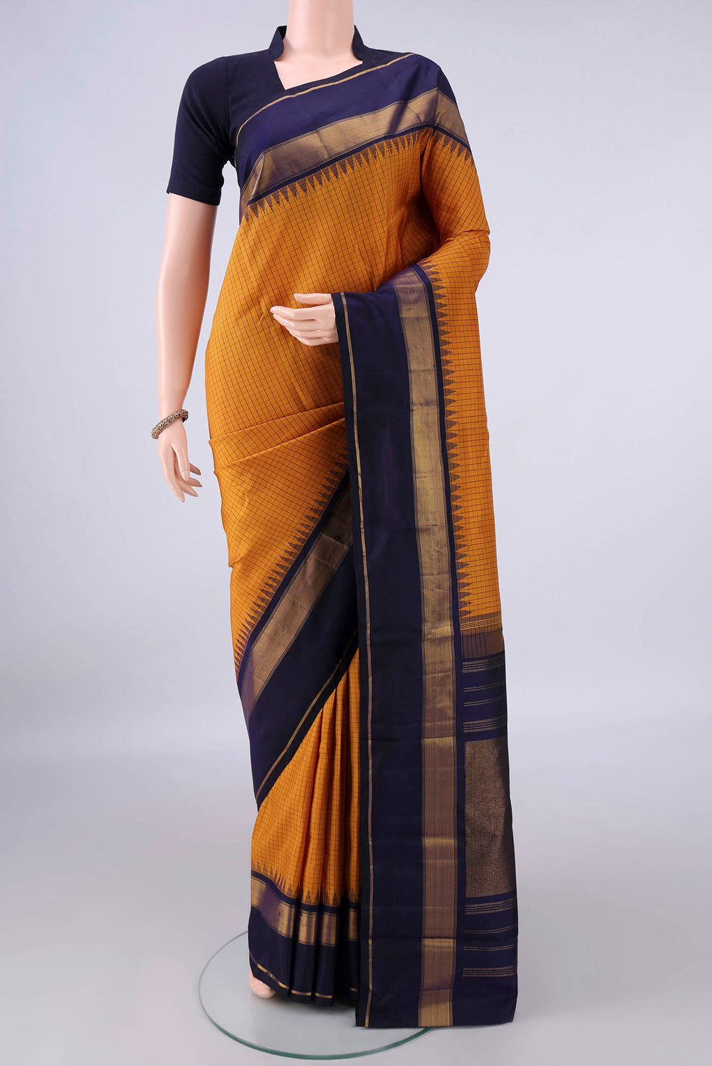 Pure Silk Mustard Kanjivaram Saree with Checked design on the body and Zari Border.  displayed on a mannequin