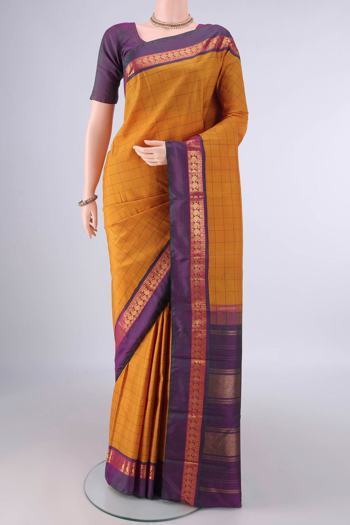 Pure Silk Mustard Kanjivaram Saree with Checked design on the body and Zari Border.  displayed on a mannequin