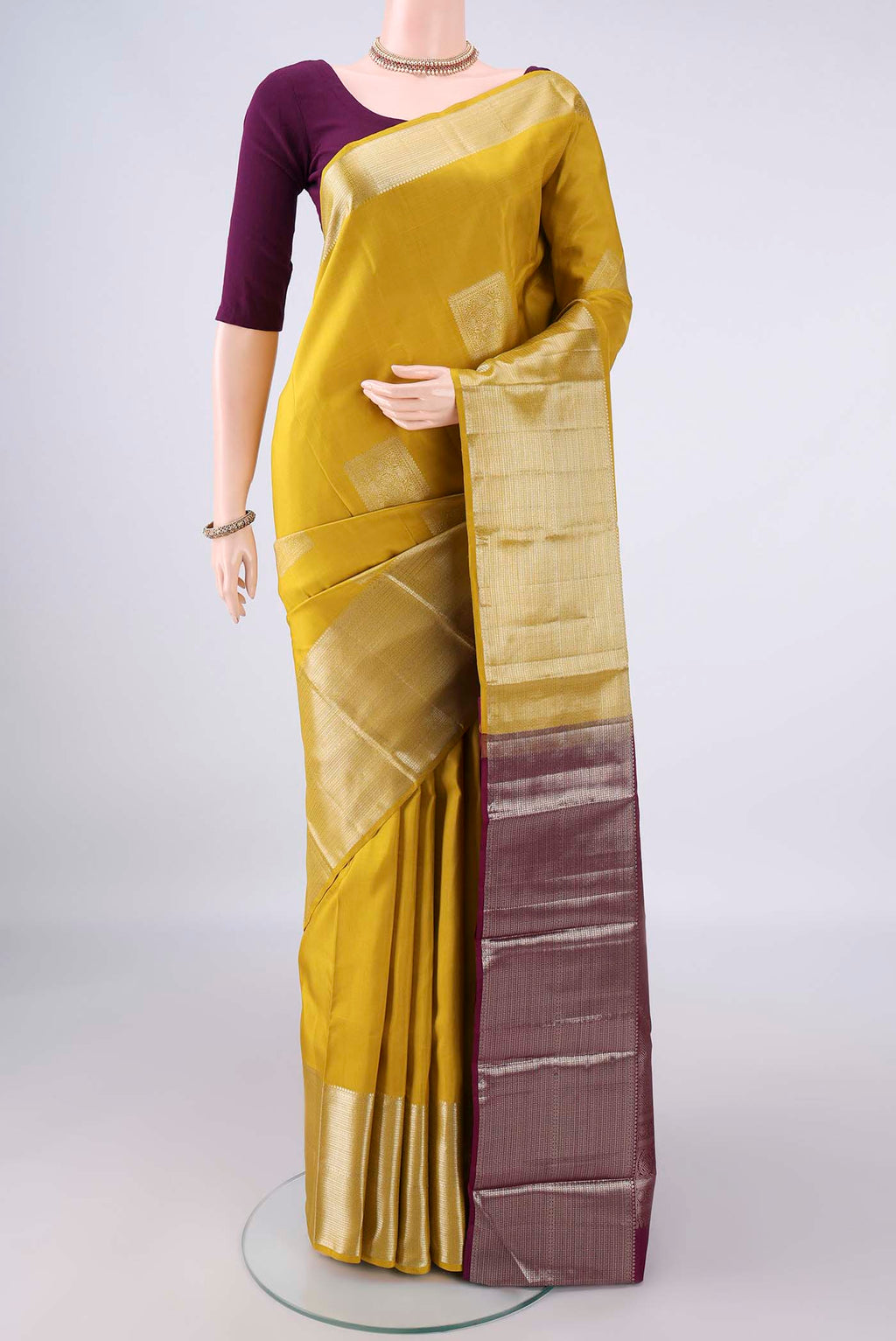 Pure Silk Mustard Kanjivaram Saree with Plain Body and Zari Border.  displayed on a mannequin