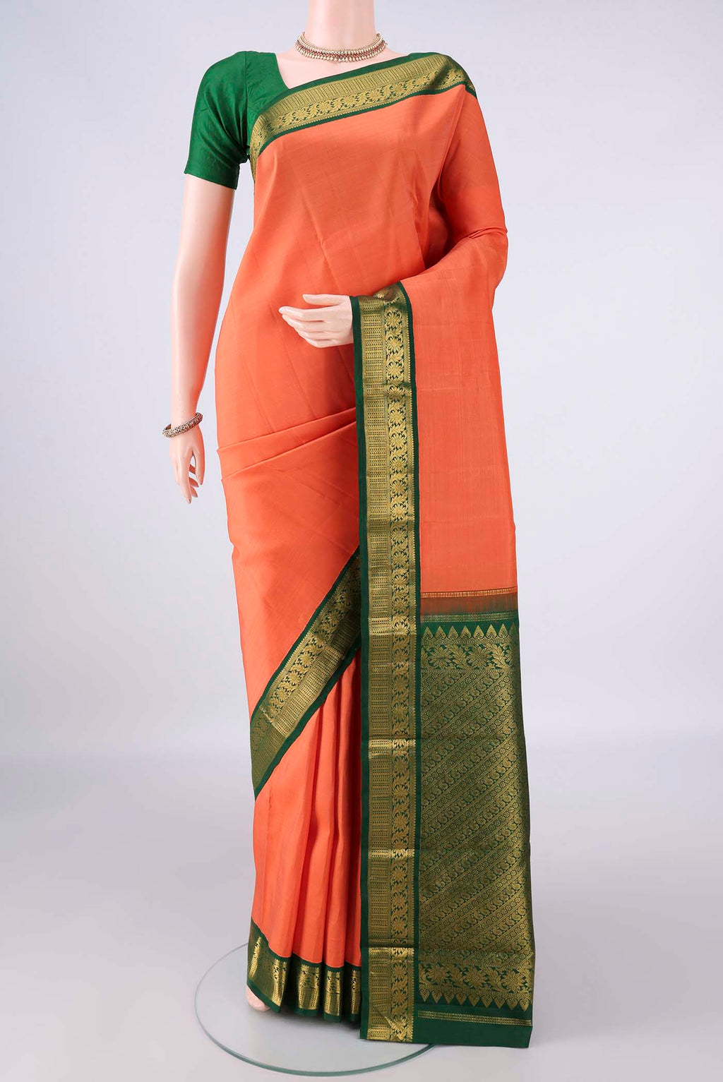 Pure Silk Brick Orange Kanjivaram Saree with Plain Body and Zari Border.  displayed on a mannequin