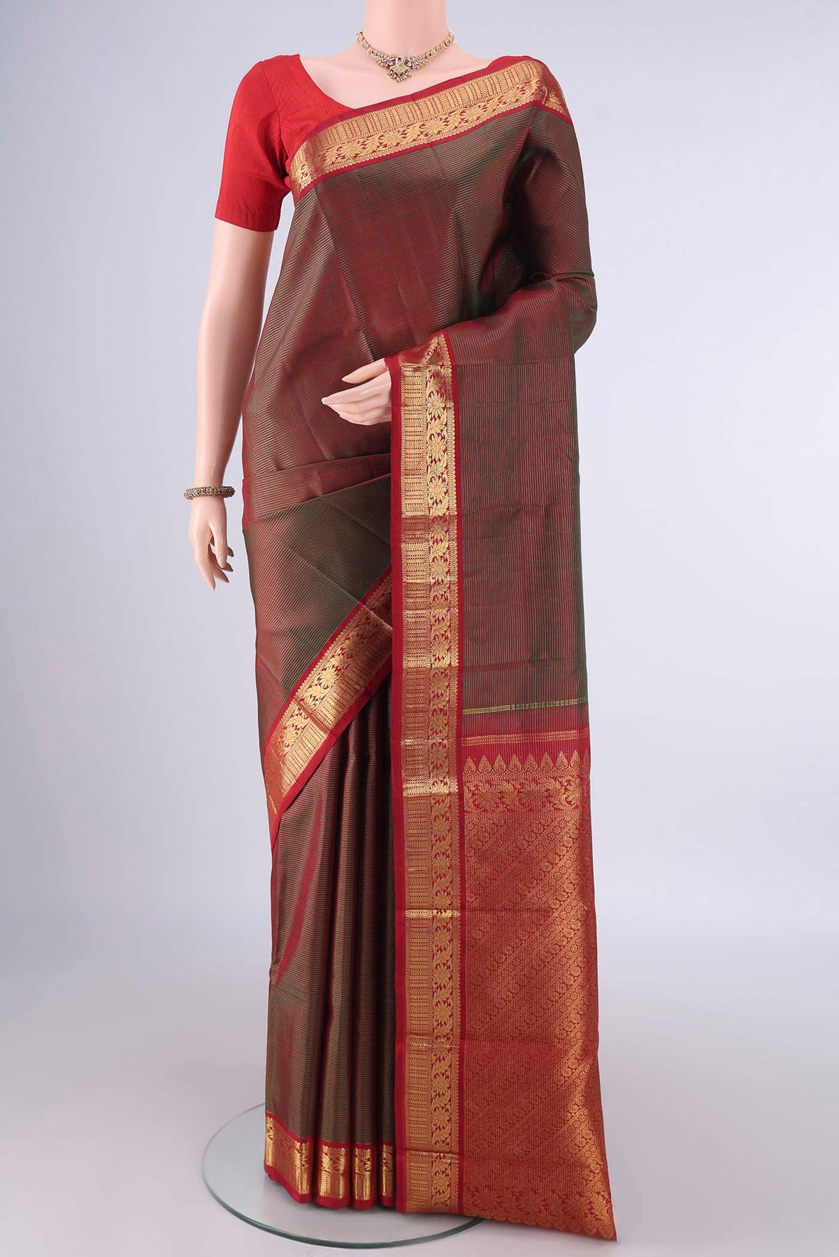 Pure Silk Green with Red Color Kanjivaram Saree with Stripes on the body and Zari Border.  displayed on a mannequin