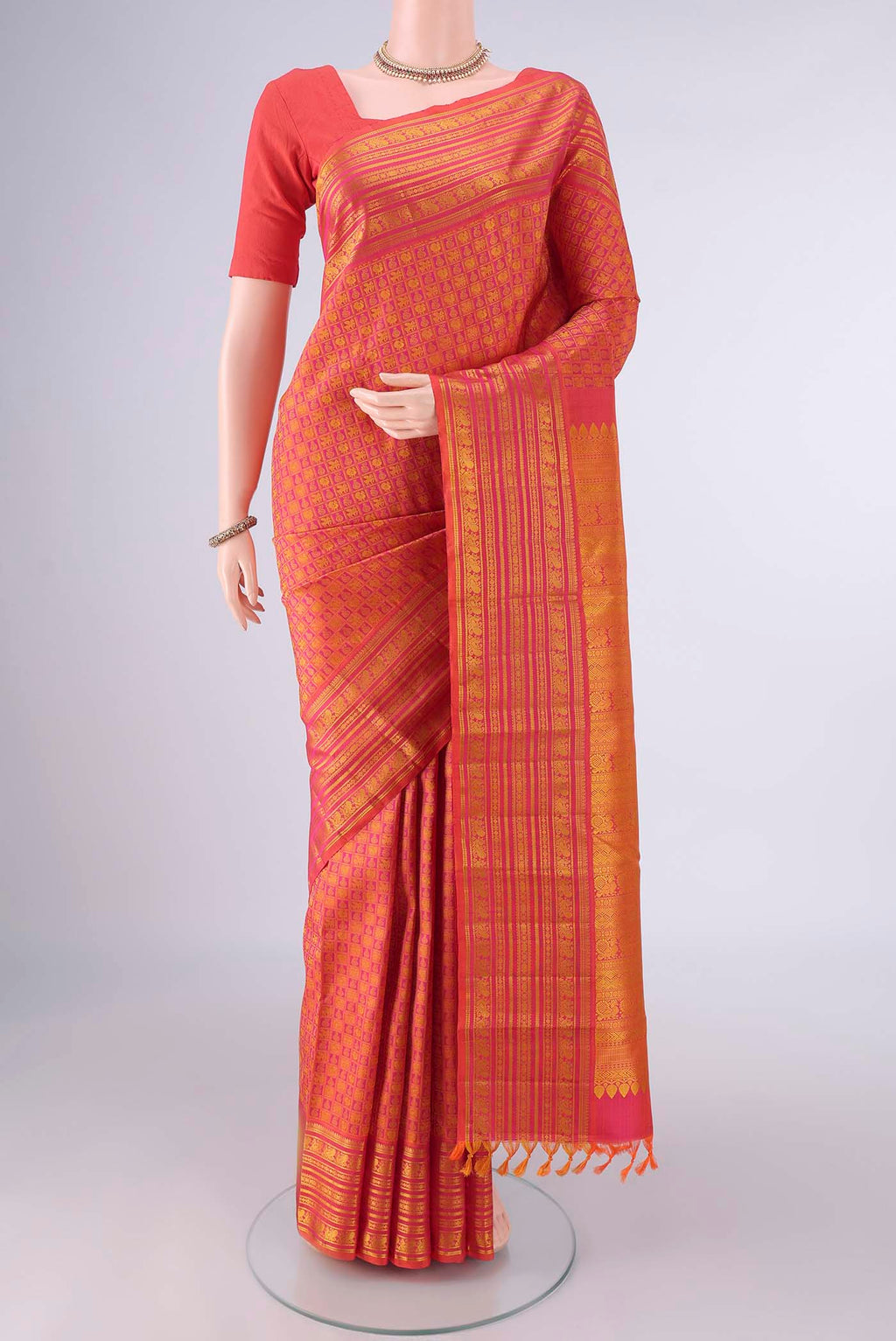 Pure Silk Brick Orange Kanjivaram Saree with Jacquard design on the body and Thread Border.  displayed on a mannequin