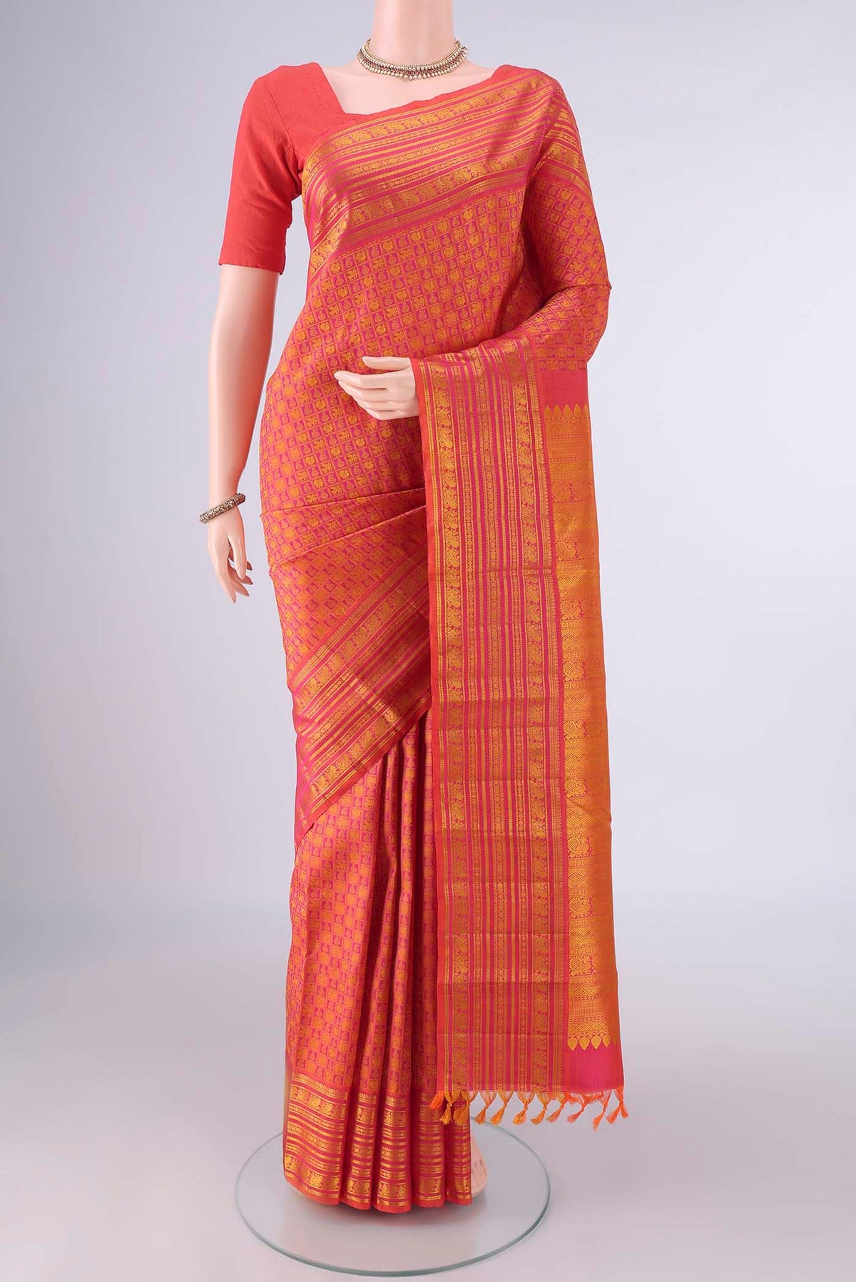 Pure Silk Brick Orange Kanjivaram Saree with Jacquard design on the body and Thread Border.  displayed on a mannequin